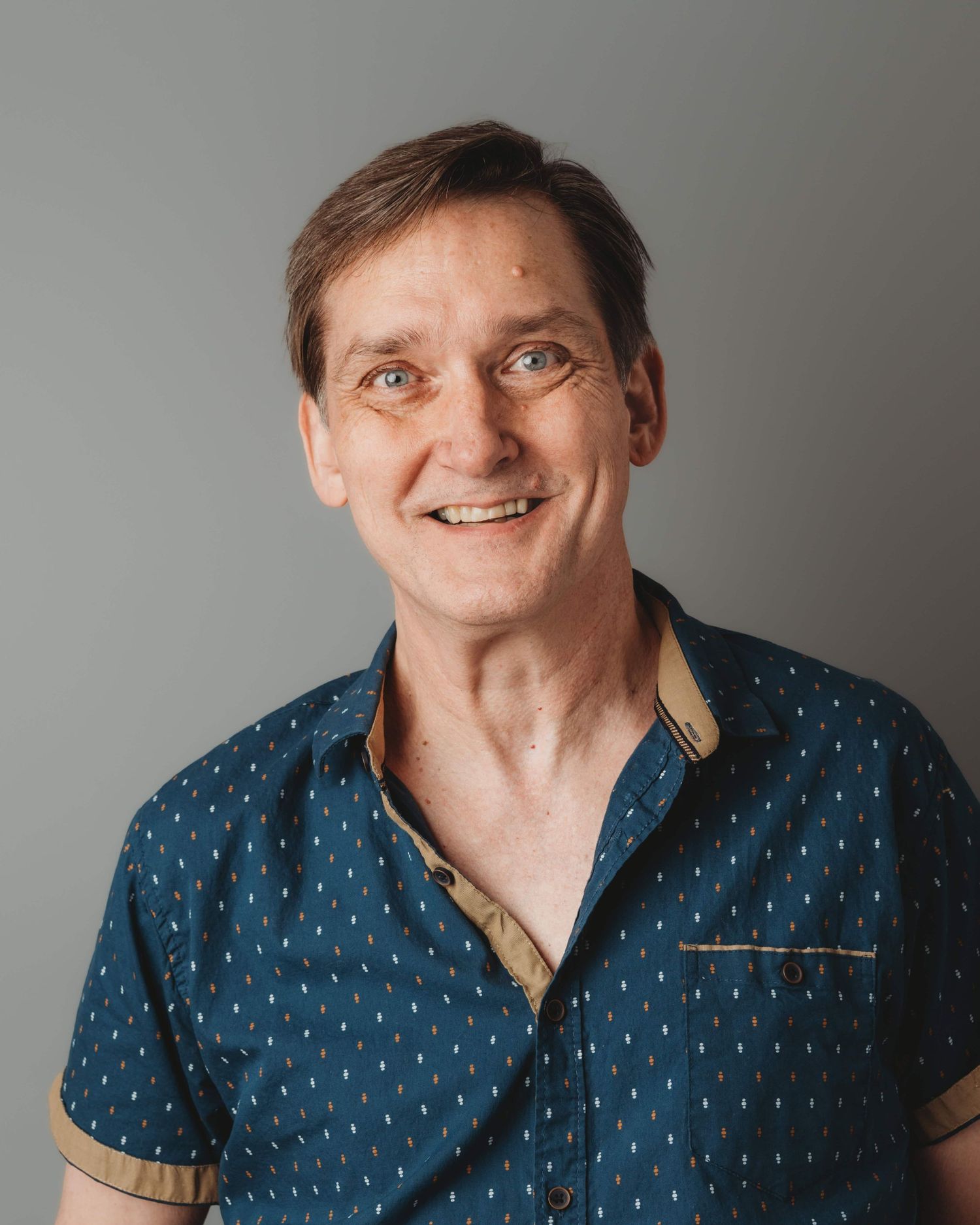 A professional headshot of a man on a gray backdrop at a Walla Walla portrait studio.