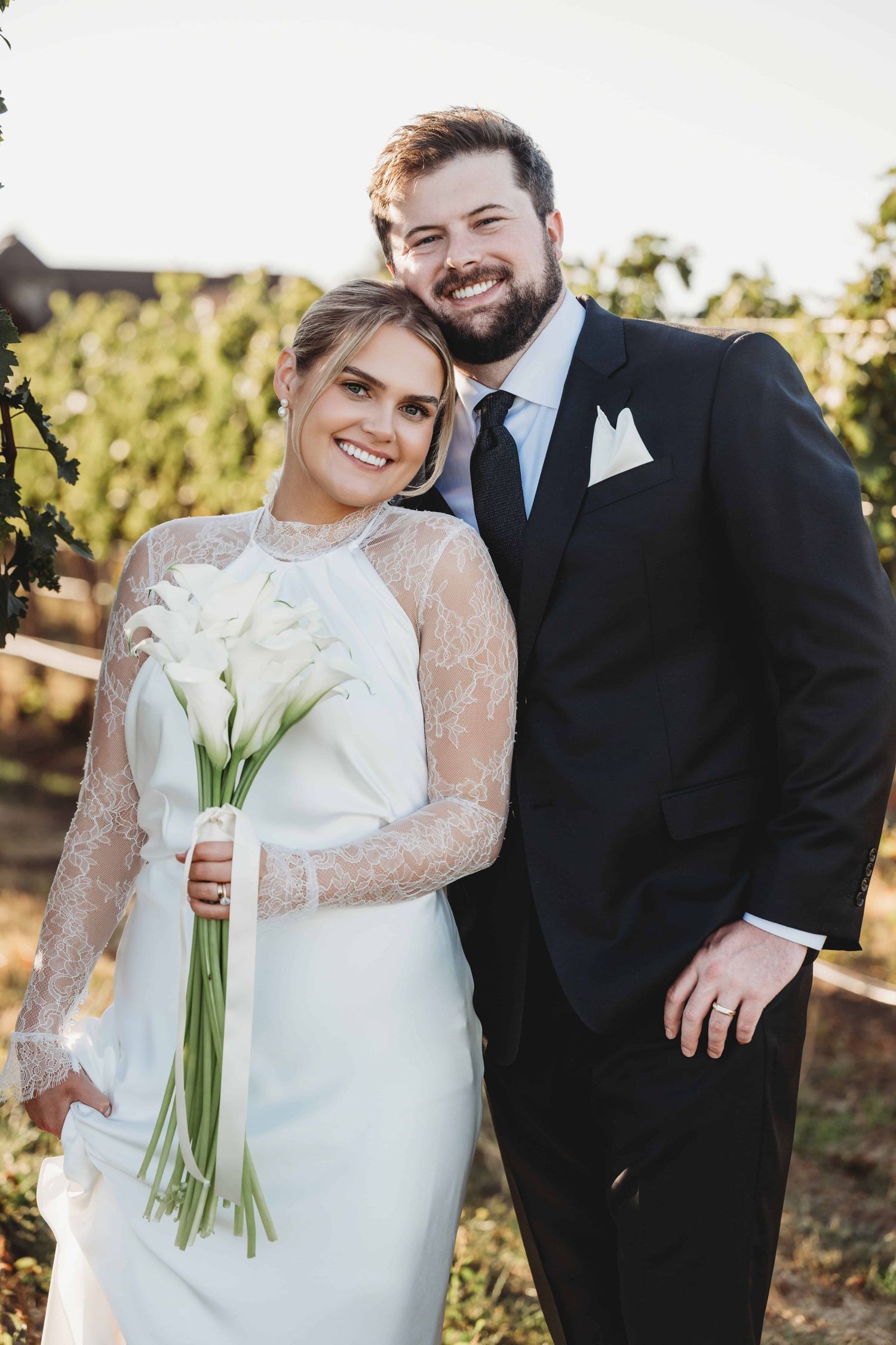 A bride and groom standing in the middle of a vineyard on a sunny day in Walla Walla.
