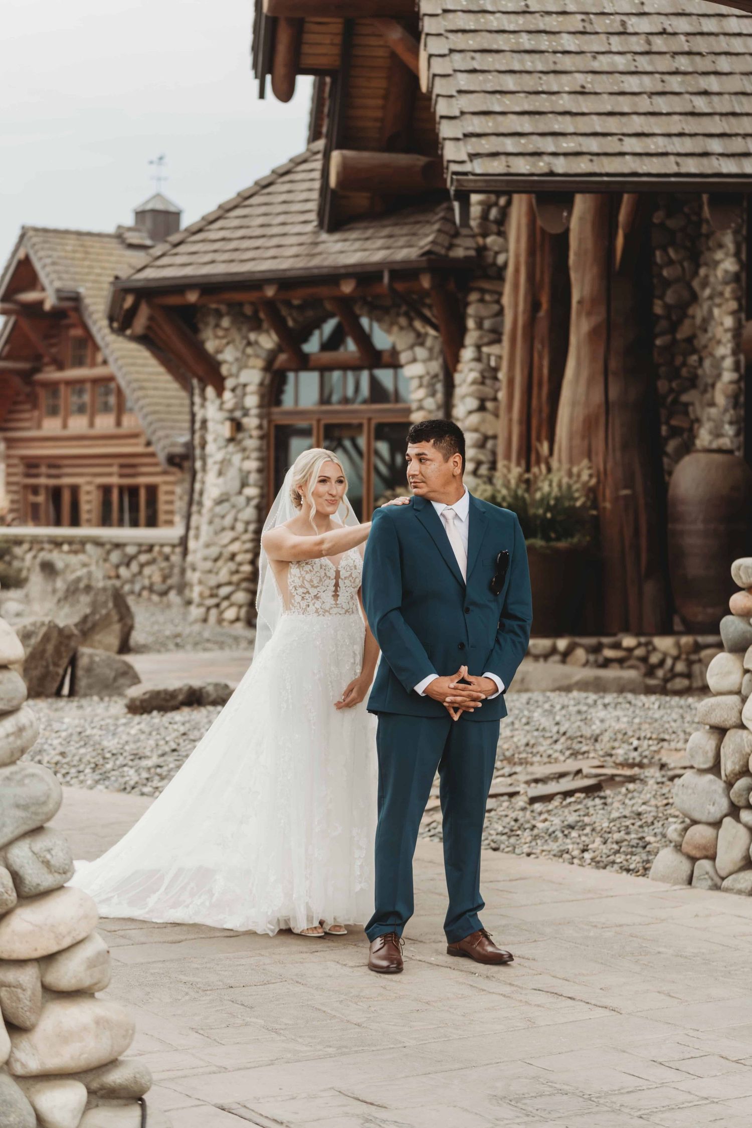 A bride taps on the grooms shoulder during their first look.