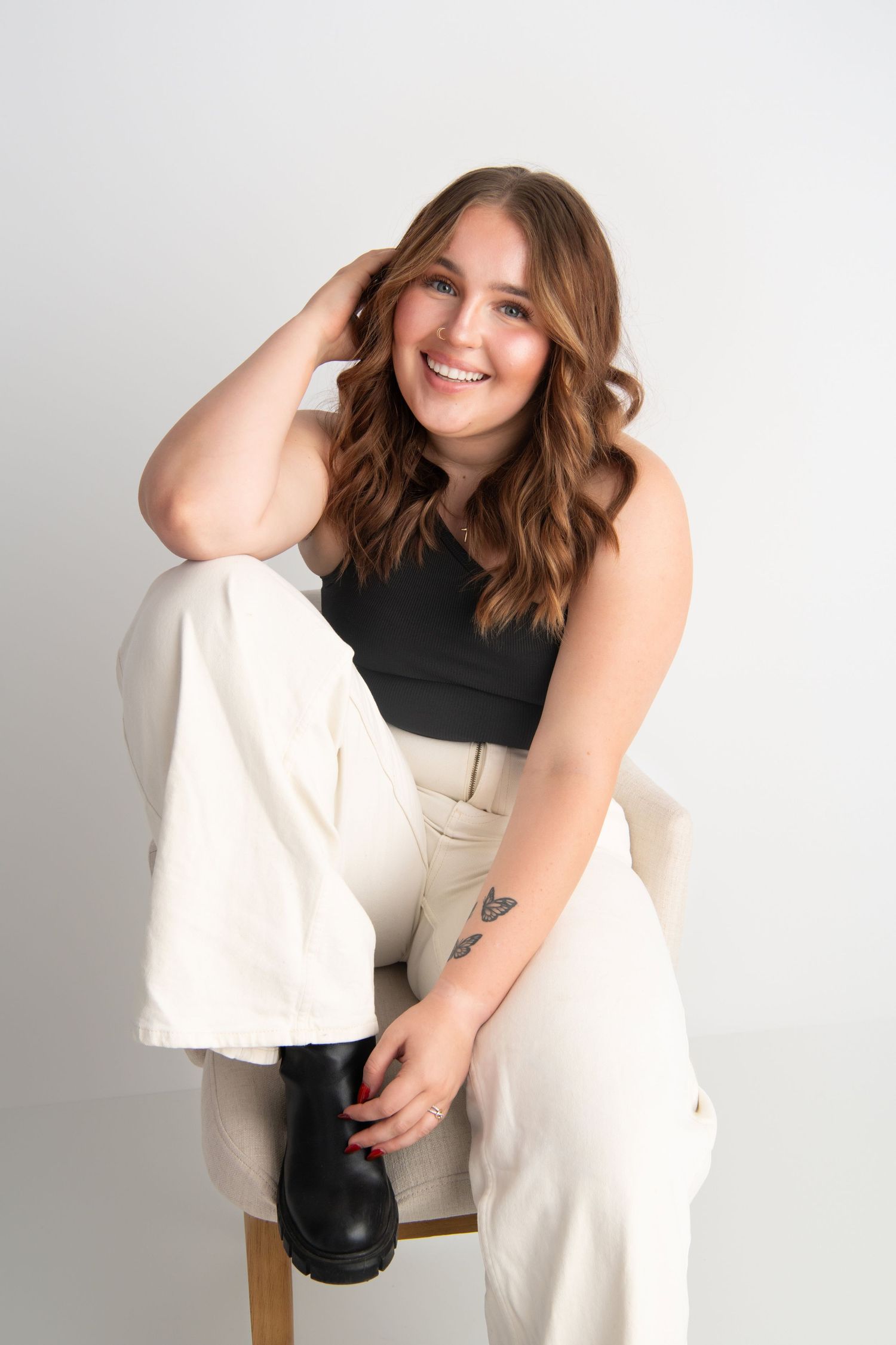 A hairdresser sitting on a chair for a headshot in Walla Walla.