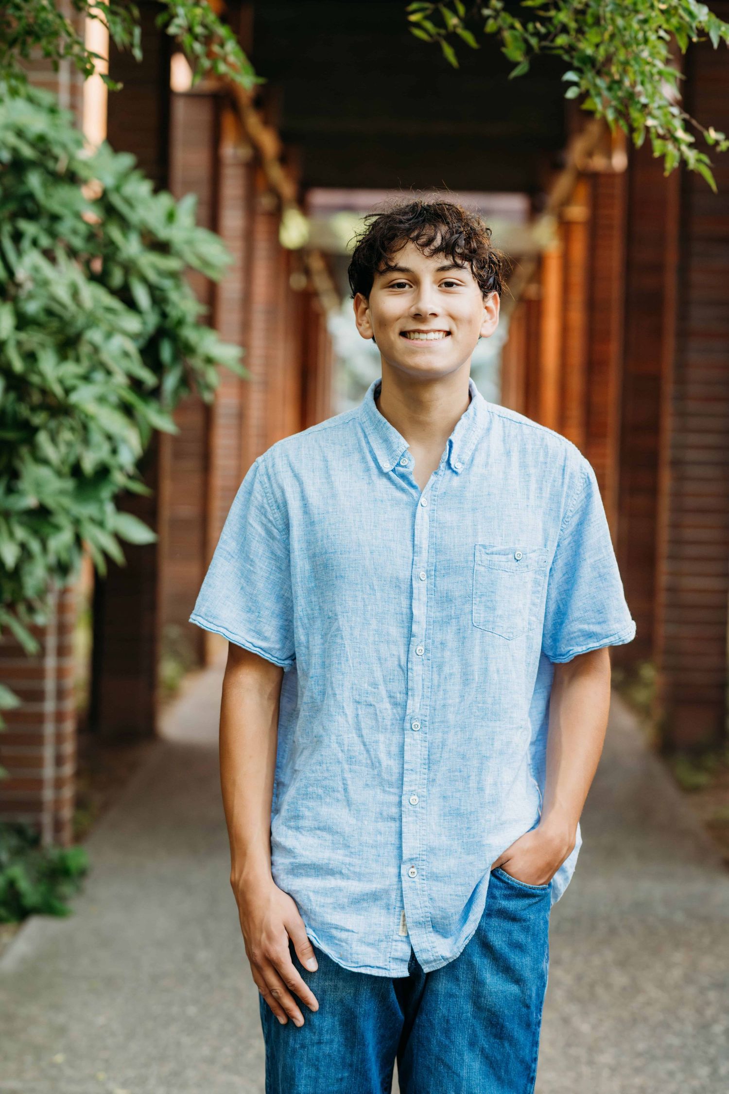 A high school senior standing between brick columns for a senior portrait at Whitman College in Walla Walla.