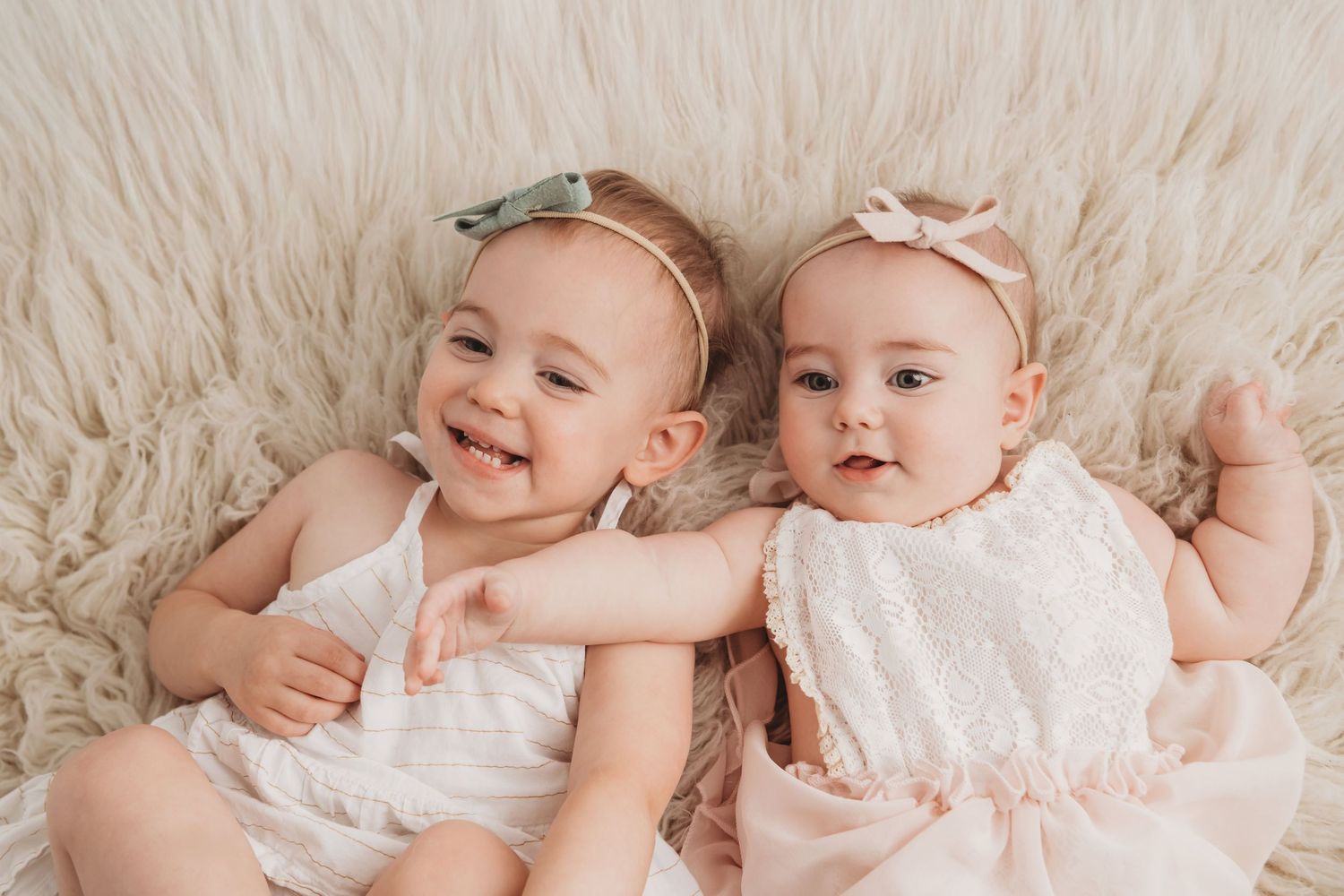 Two sisters lay on a soft cream flokati for a portrait in Walla Walla.