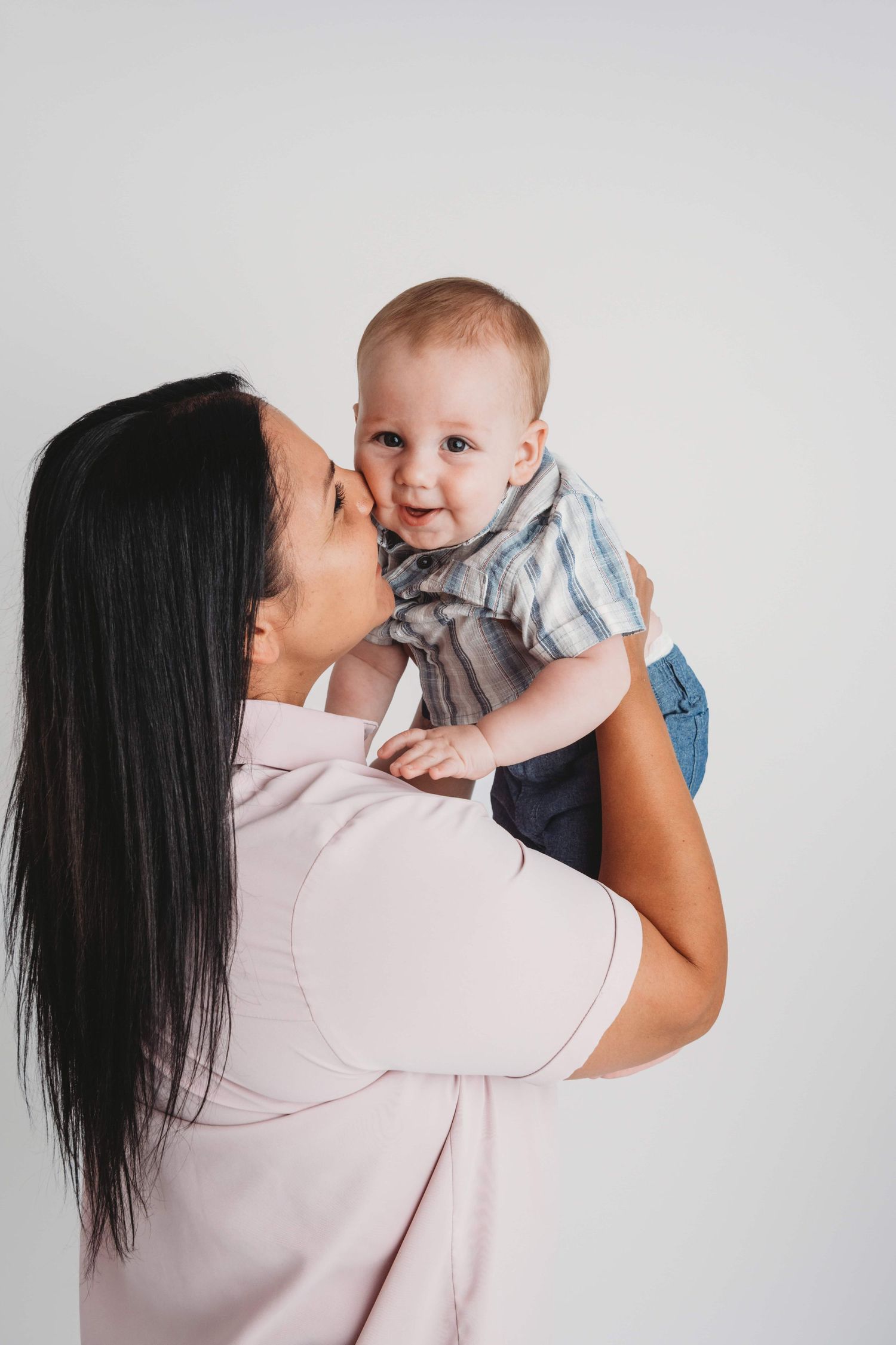 A portrait of a mom and her baby boy on a white backdrop in a Walla Walla studio.