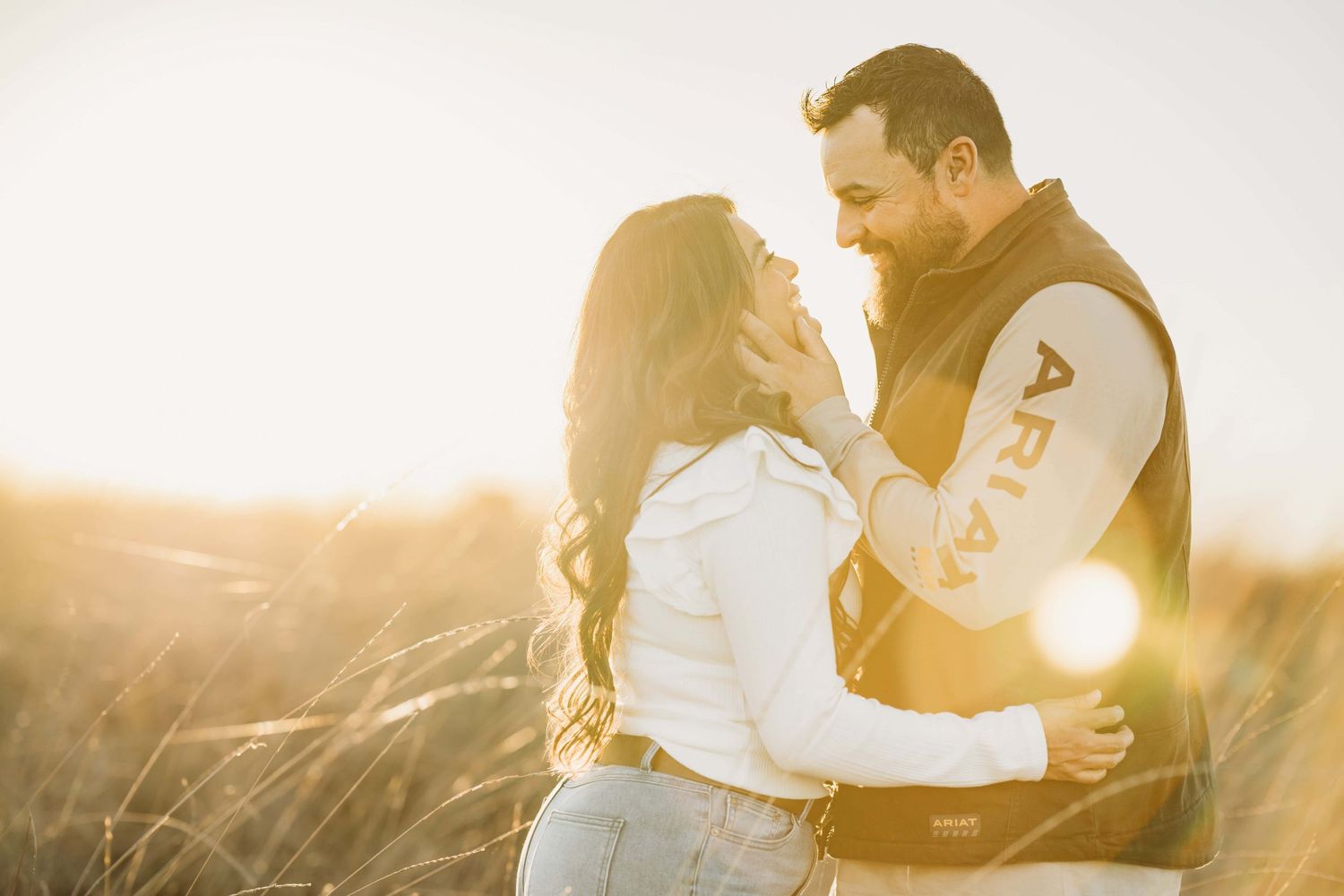 A golden hour portrait of a couple looking at each other smiling, taken by a Walla Walla photographer.