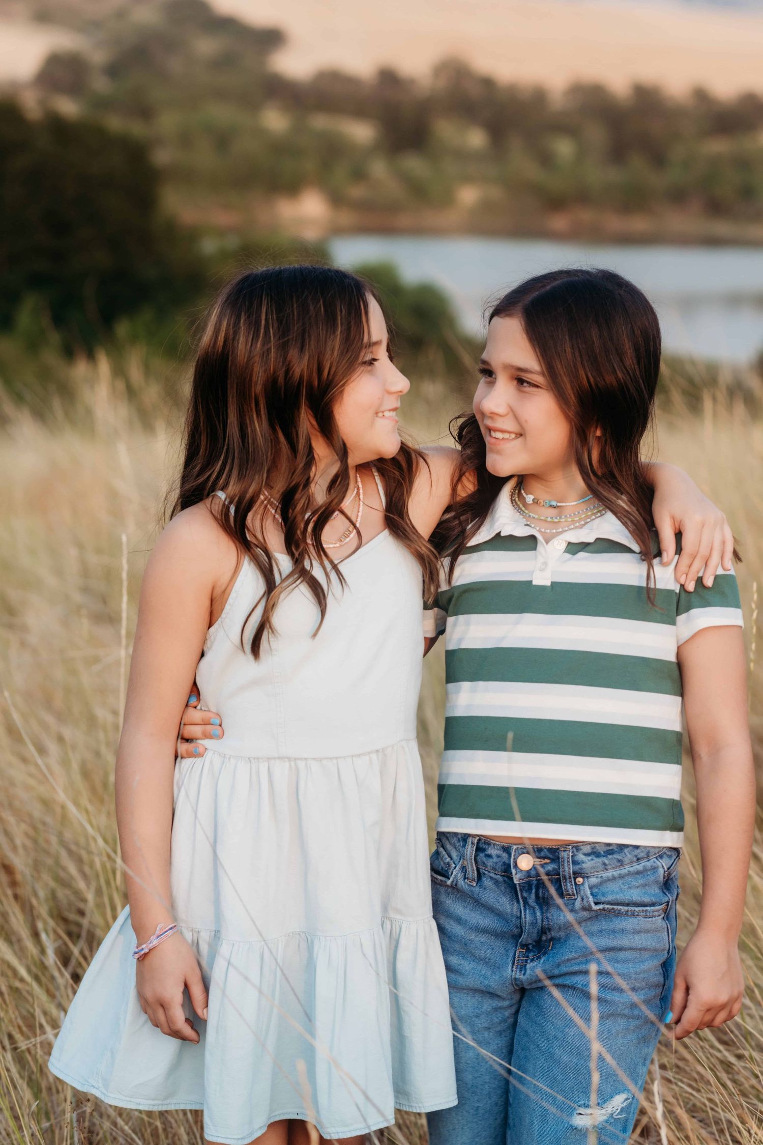 A candid moment captured by a Walla Walla photographer of twin sisters looking at each other.