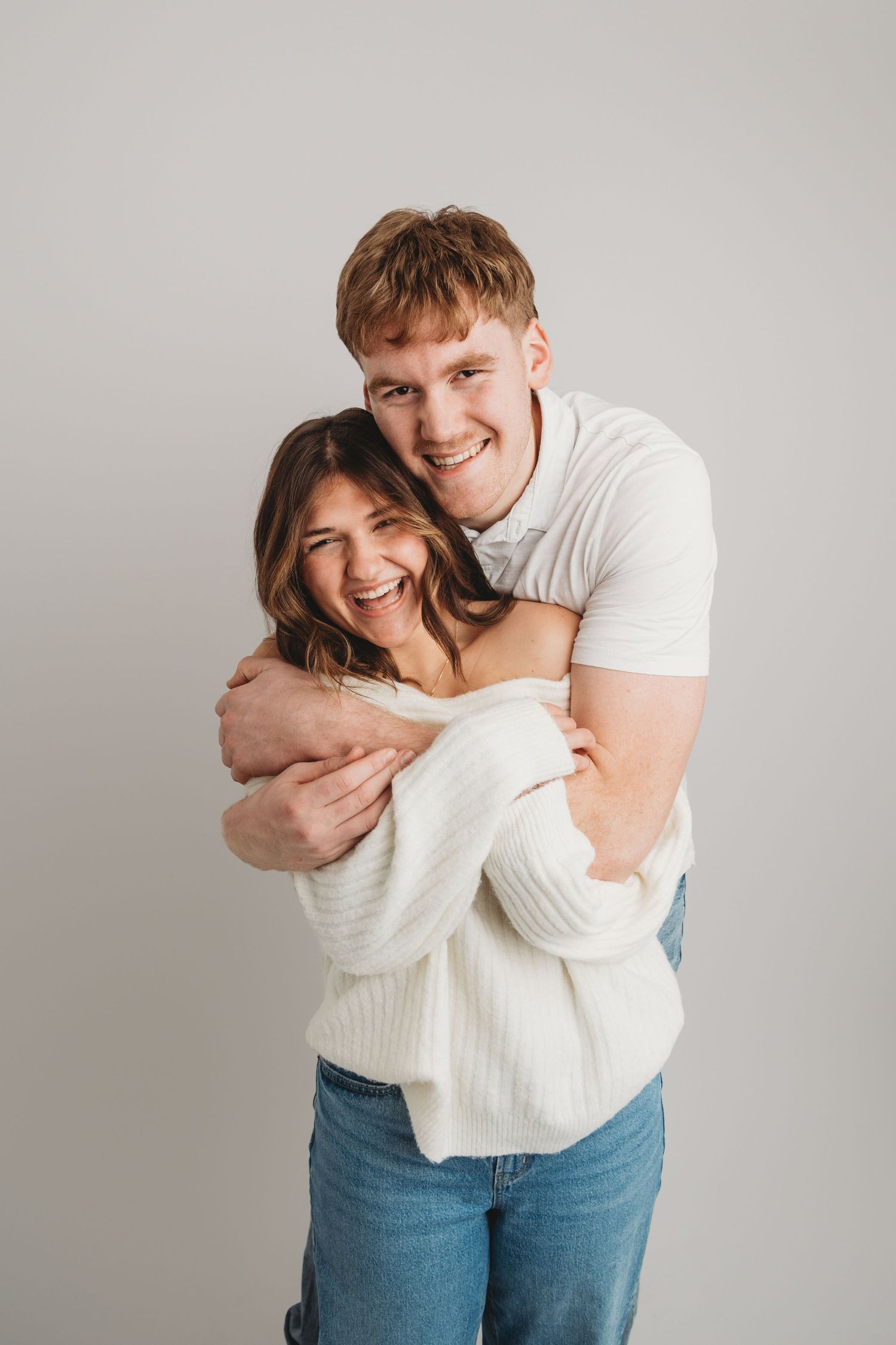 Playful studio couples portrait of a young couple laughing together, photographed at a Walla Walla portrait studio.