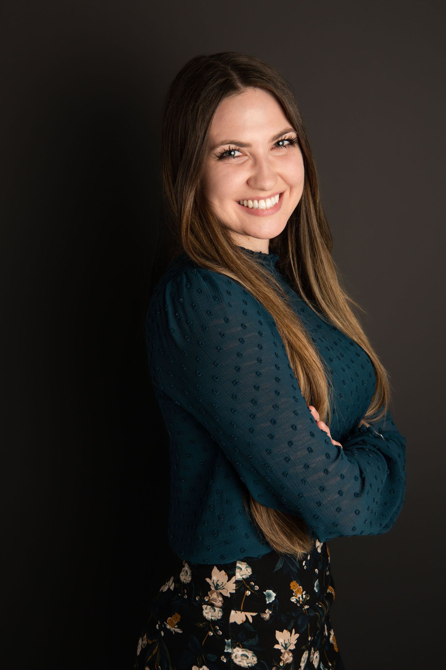 A woman standing on a black backdrop for a professional headshot in Walla Walla.