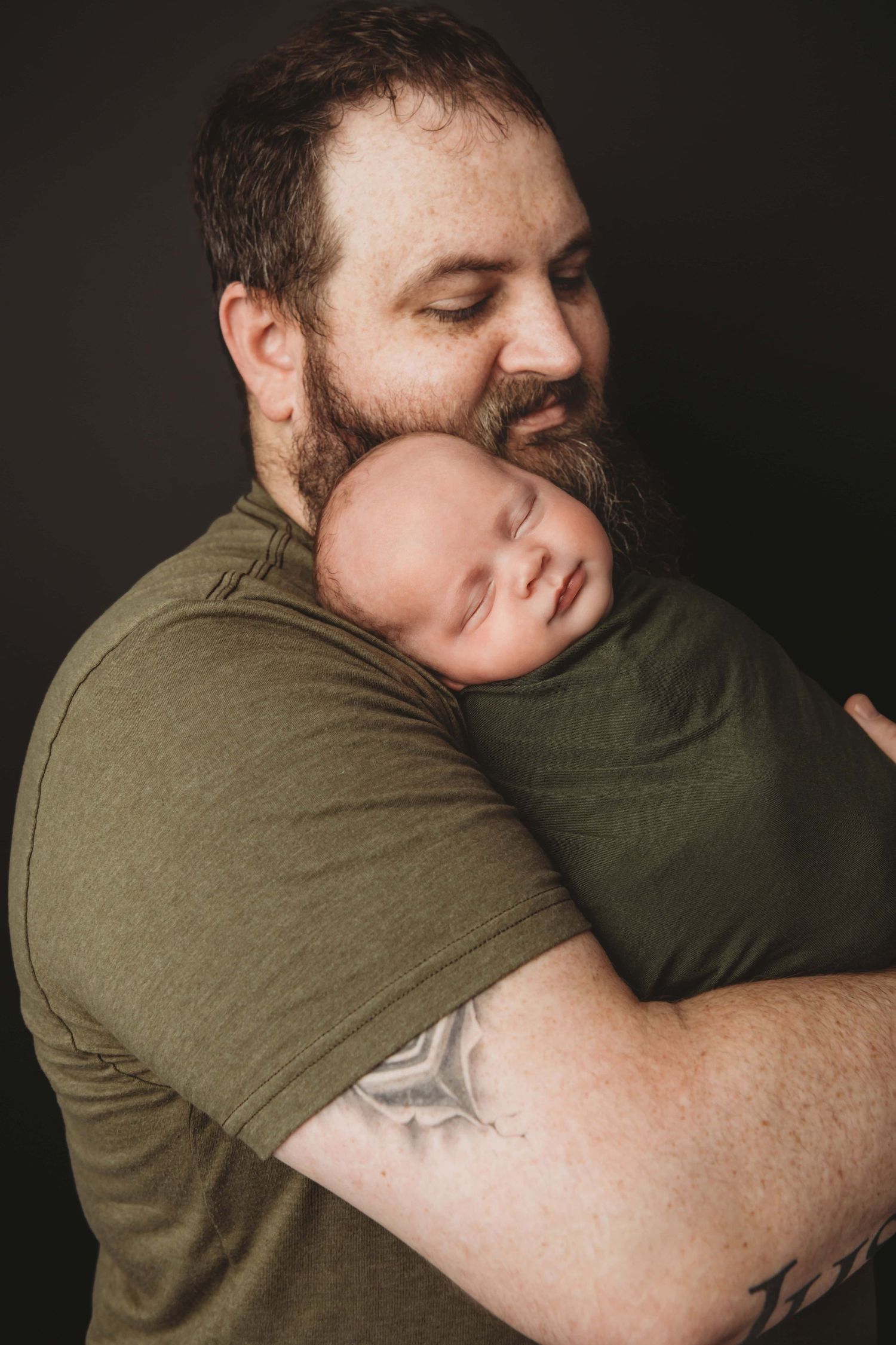Newborn sleeping in his dad's arms