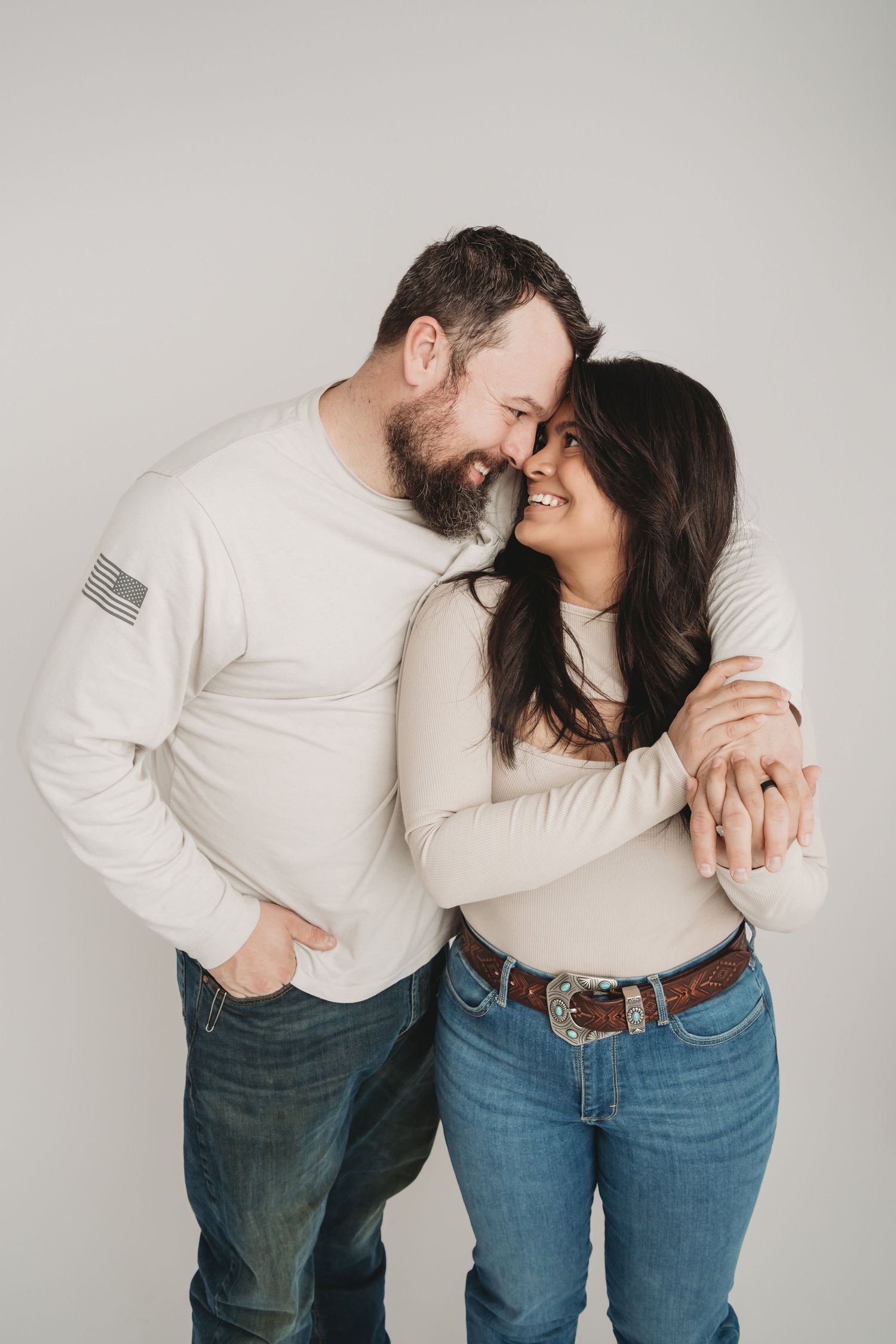 Couple holding hands in a close embrace during a studio couples portrait session in Walla Walla