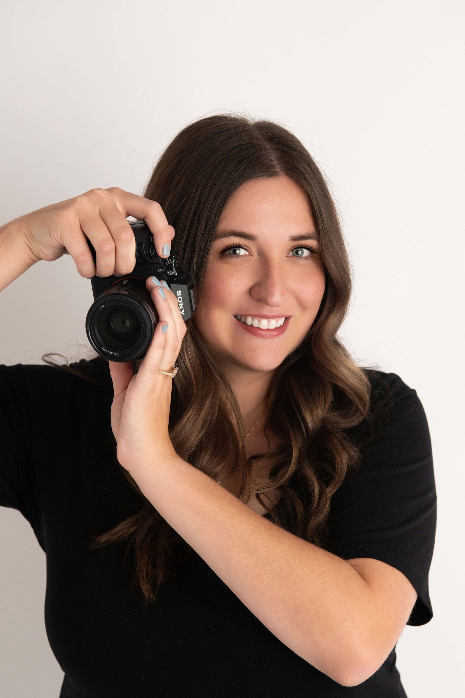 Portrait of Brittani Smith holding a camera, a Walla Walla portrait and wedding photographer.