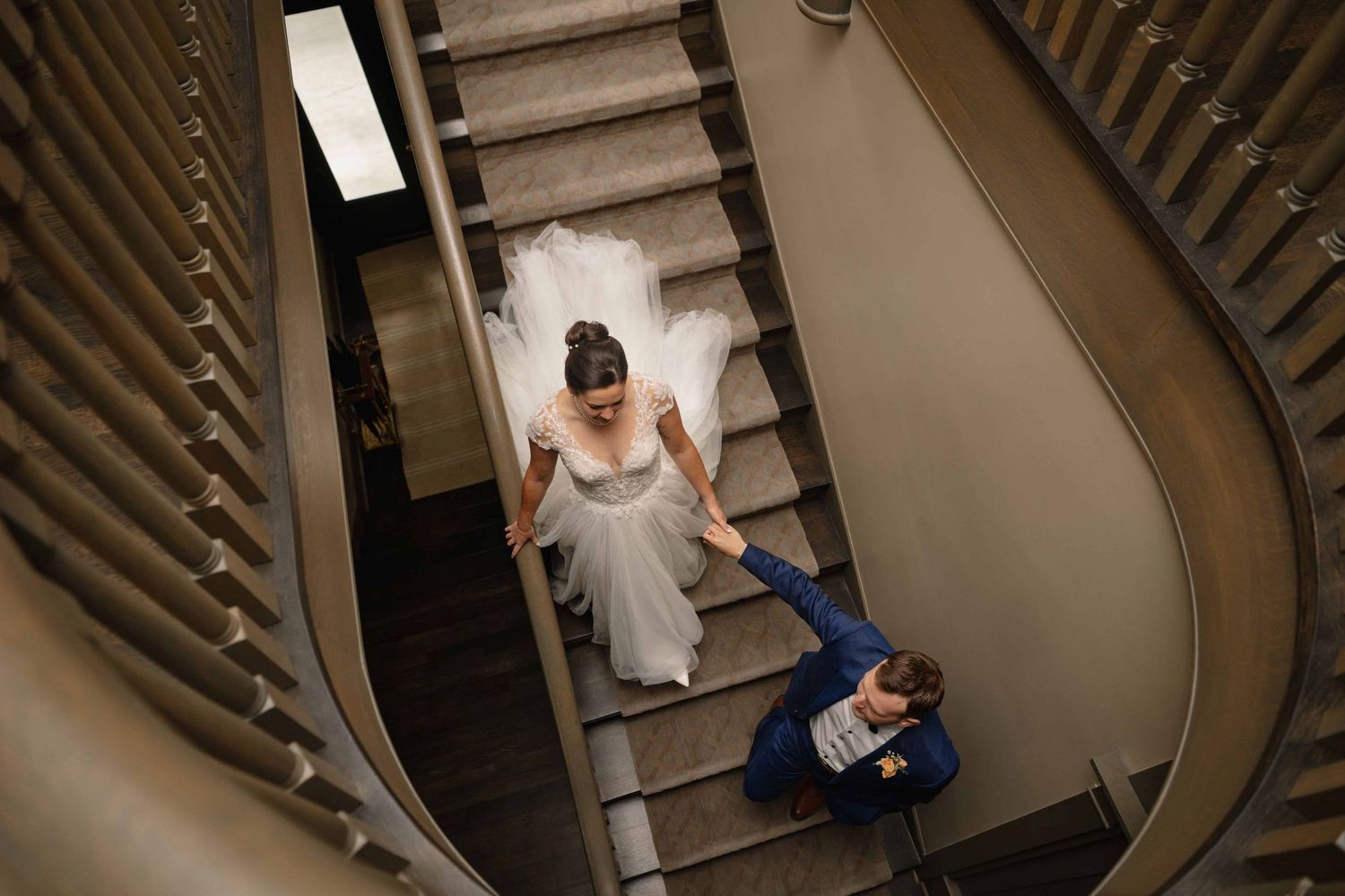 A photo of a couple walking down a staircase, taken from above.