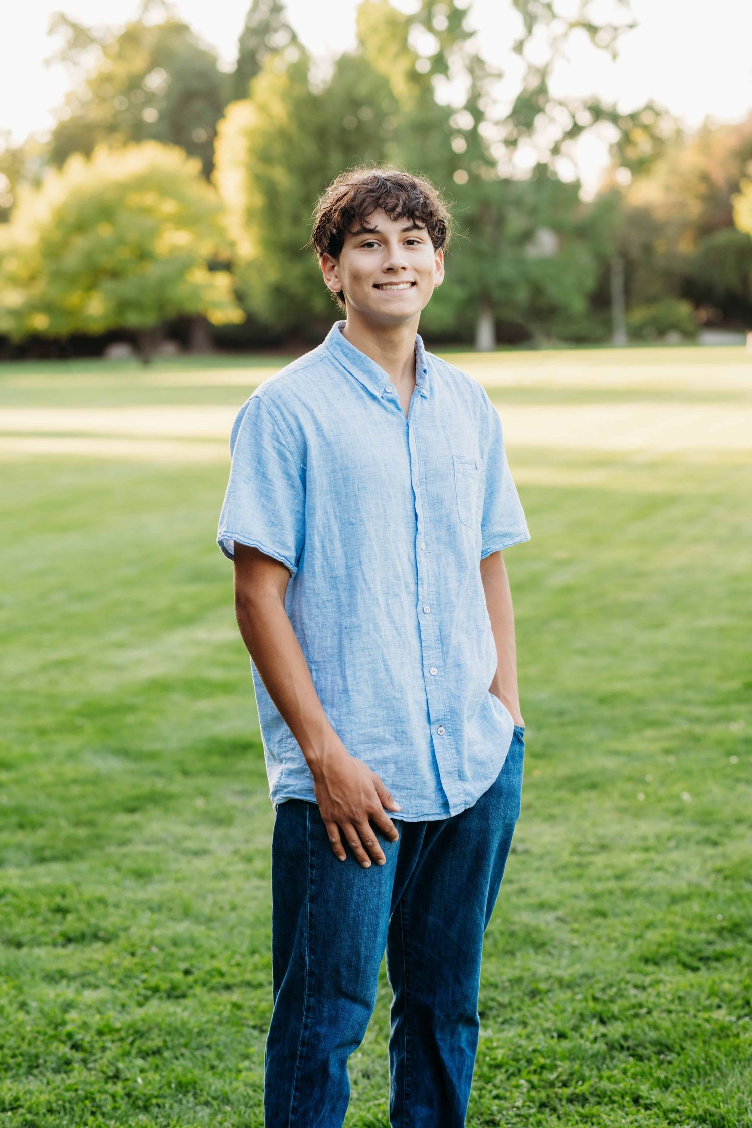 A young man standing with his hand in his pocket, smiling for the camera, at Whitman College in Walla Walla.