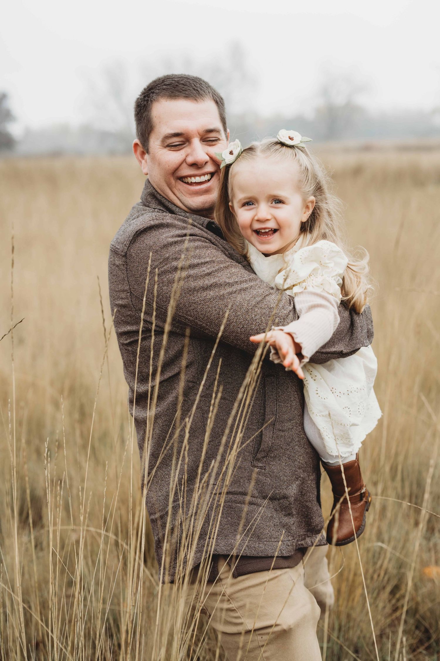 A dad and his daughter playing together in a field.