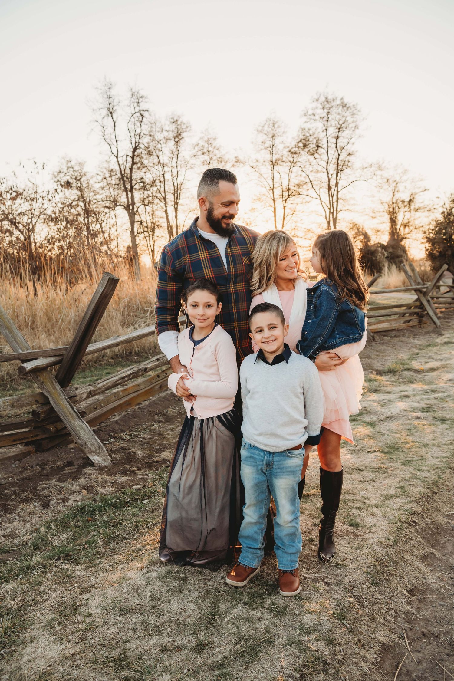 Walla Walla family photographer capturing a candid moment of parents and children laughing together at sunset.
