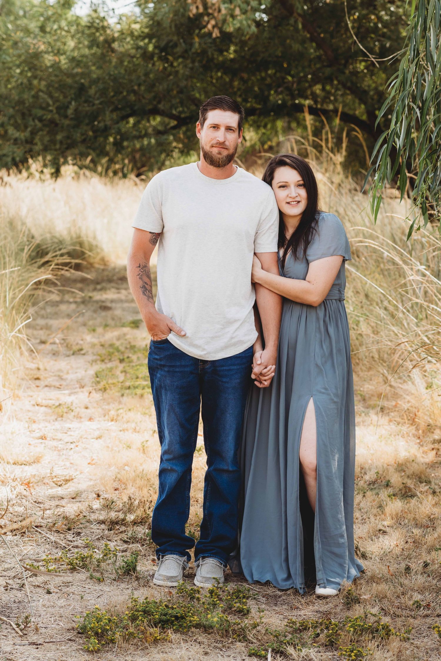 A couple holding hands with soft smiles at Whitman Mission.