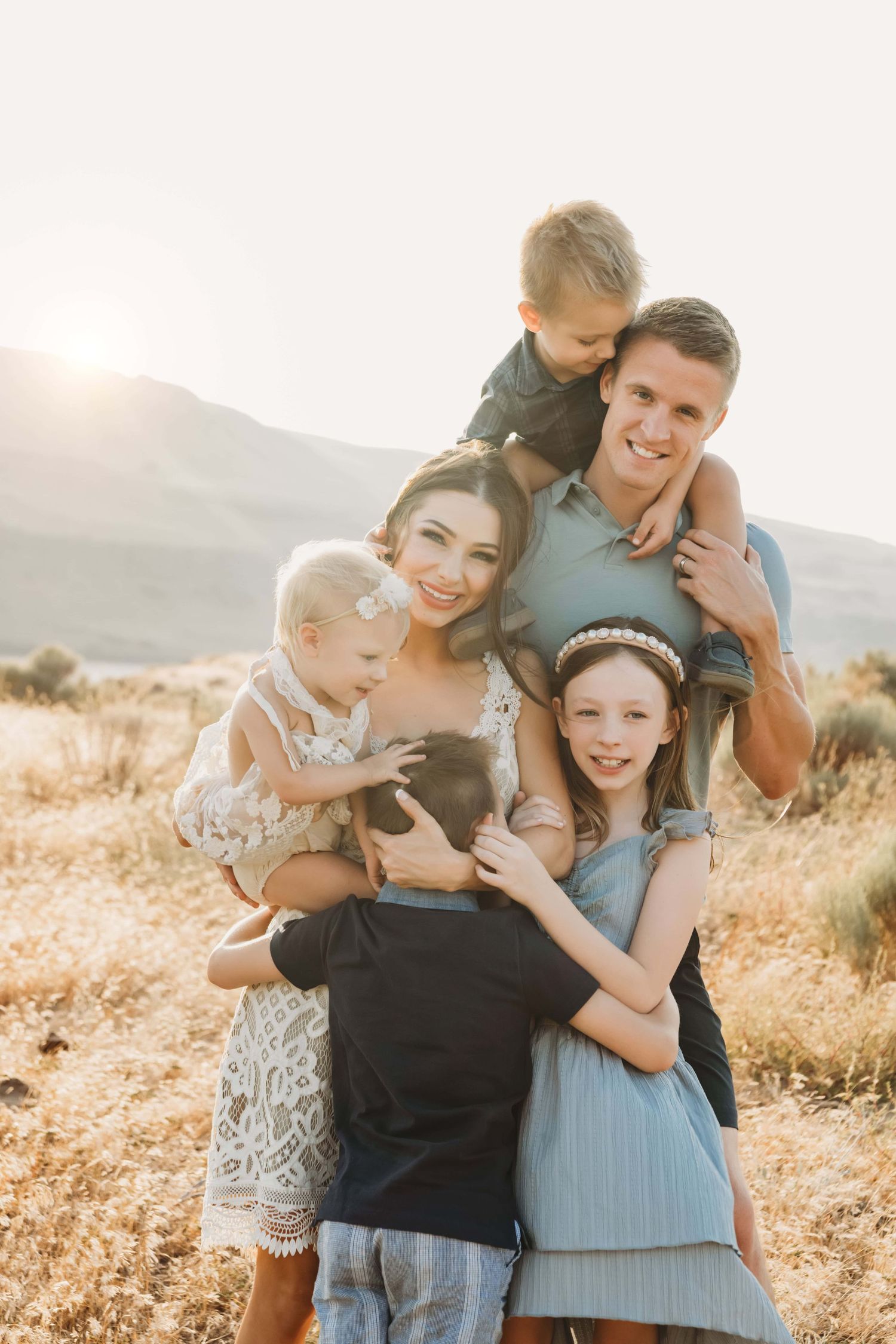 Portrait of a family hugging, with a little boy on his dad’s shoulders at Twin Sisters near Walla Walla, Washington