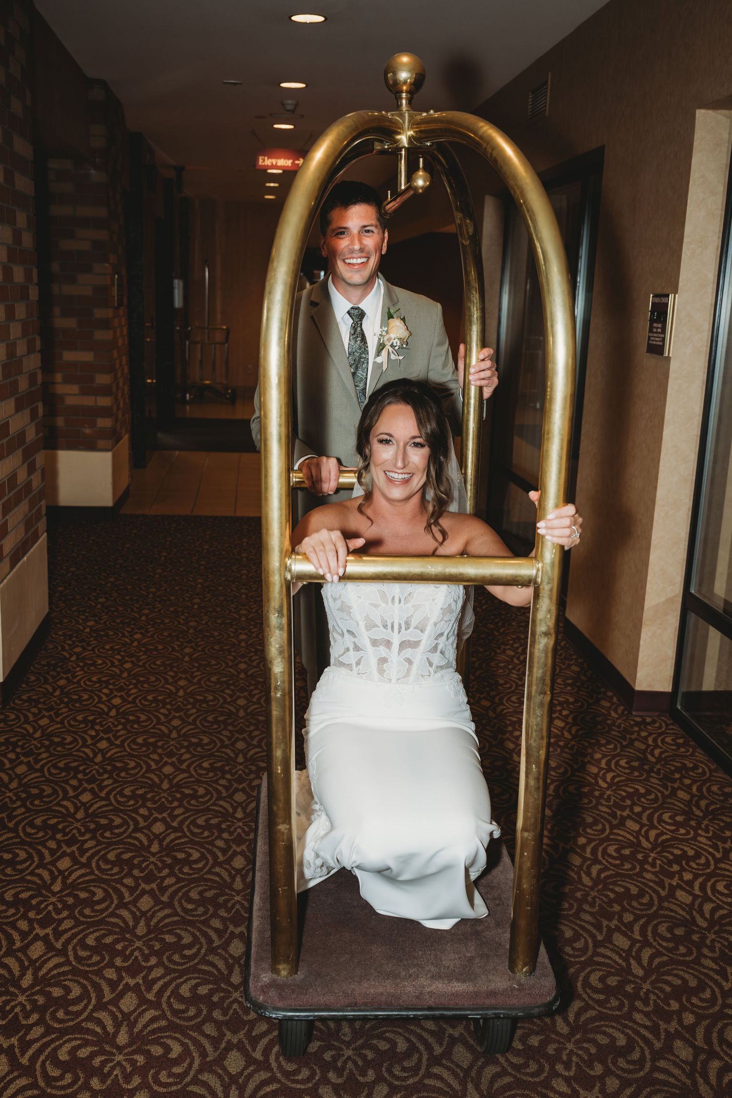 A groom pushing his bride on a luggage cart before their wedding at the Marcus Whitman Hotel in Walla Walla, Washington.