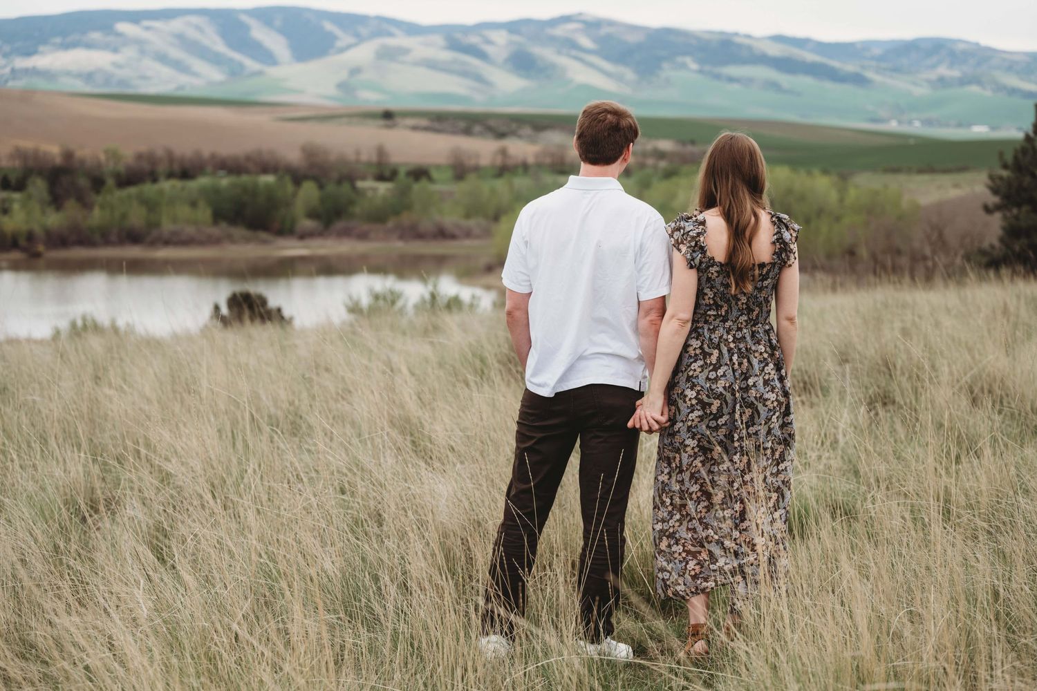 A couple from behind looking out at the lake and Blue Mountains at Bennington Lake.