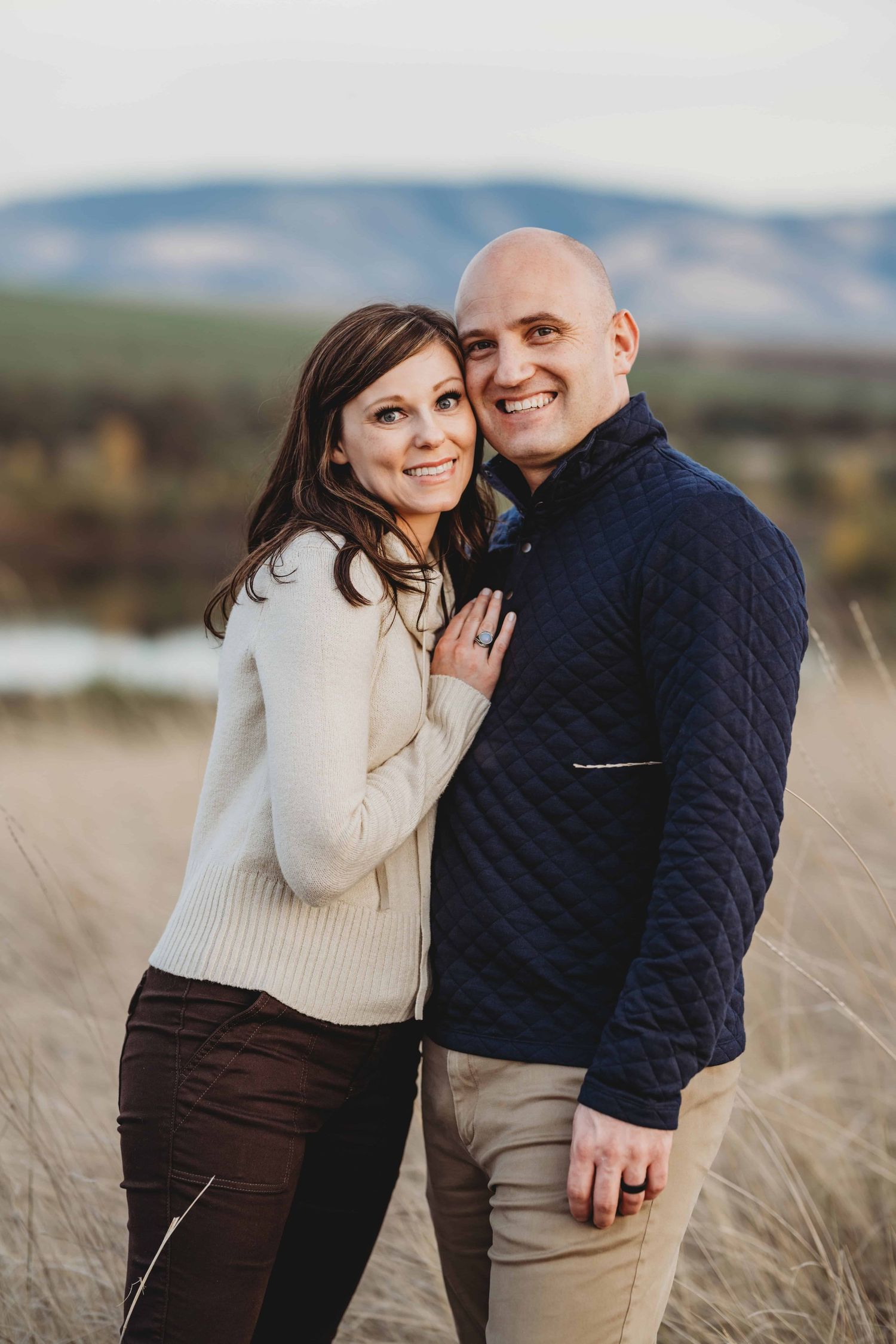 A couple looking at the camera smiling.