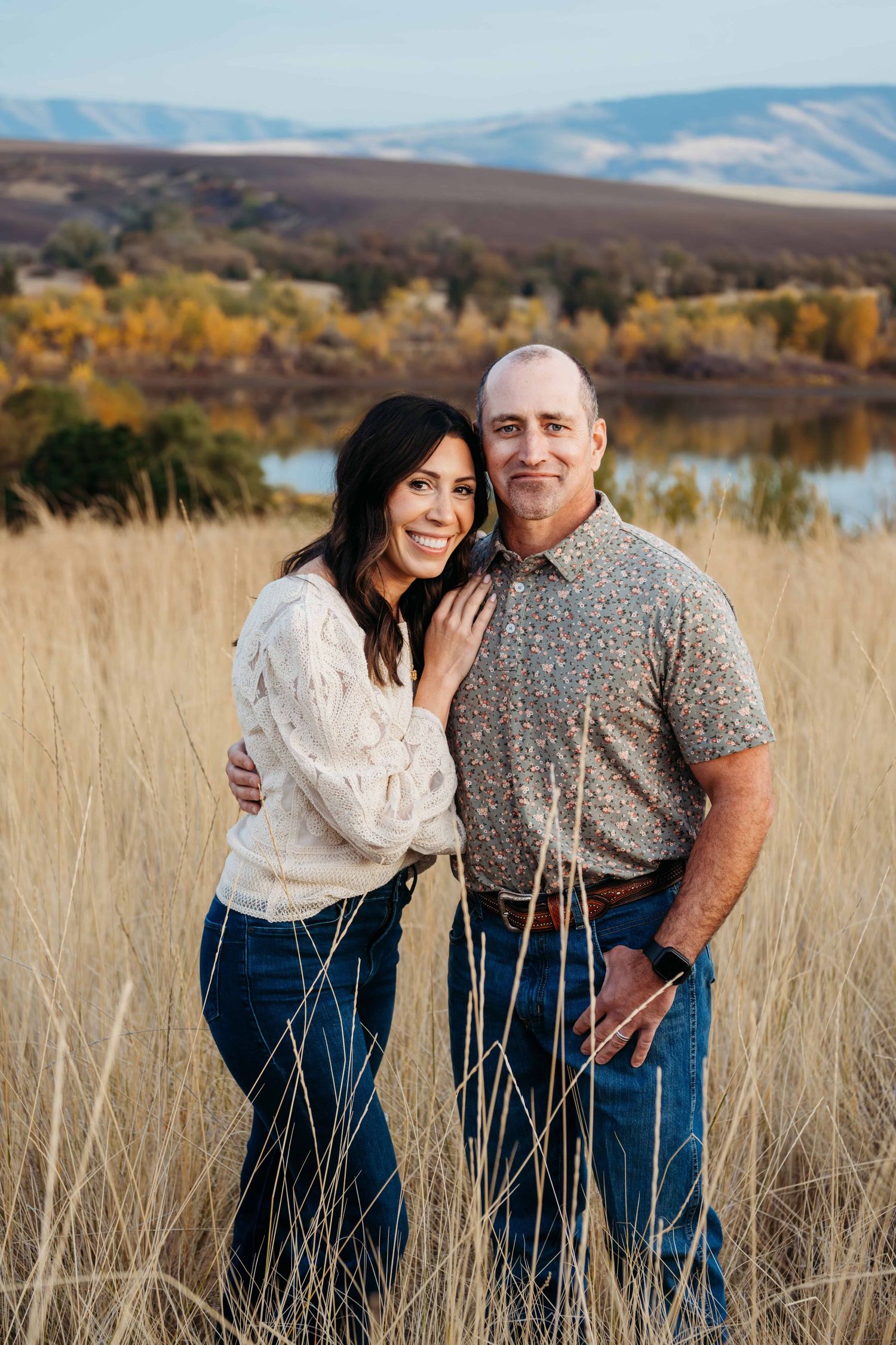 A couple standing in front of Bennington lake in walla walla smiling for the camera.