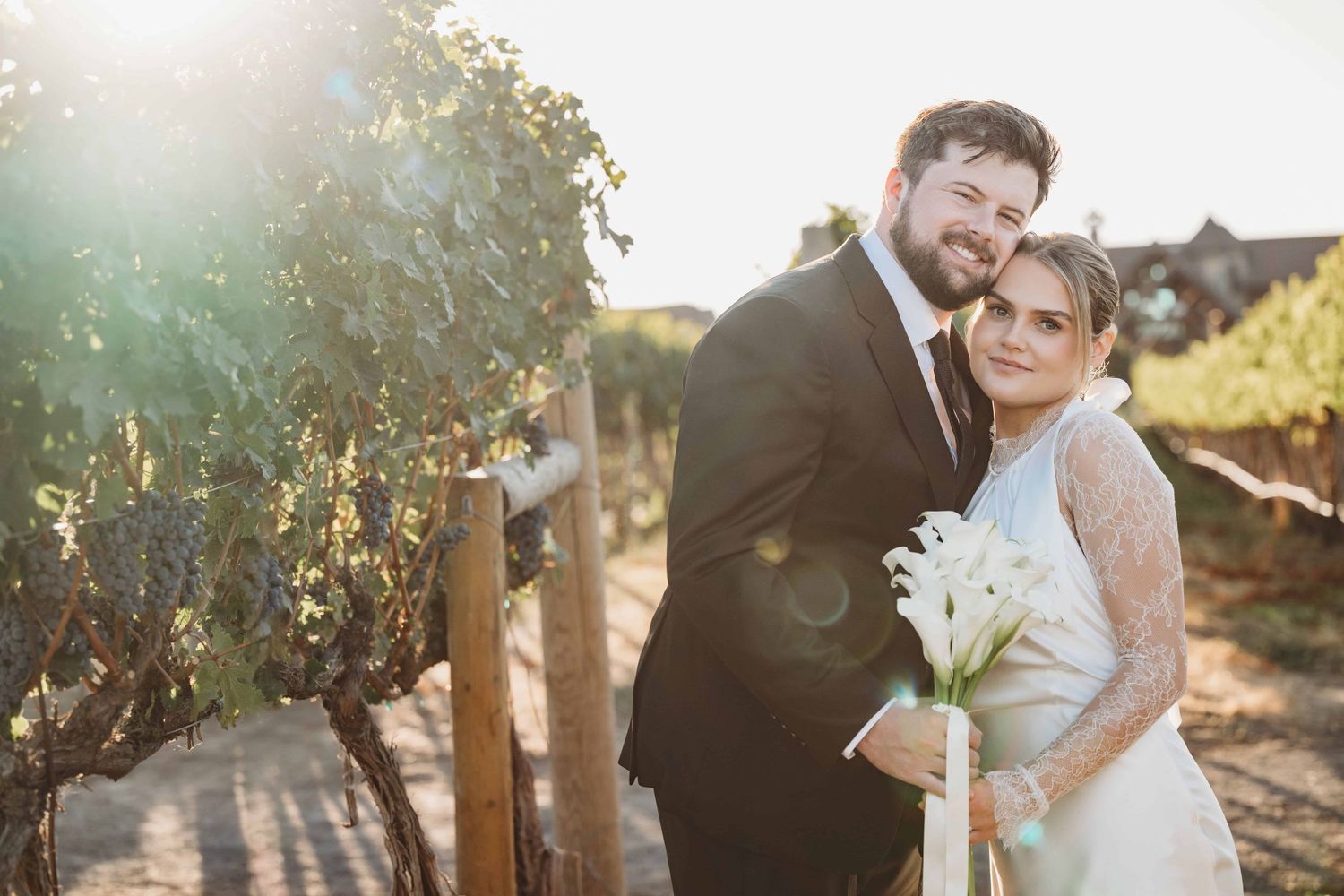 A bride and groom holding a callalily bouquet  on their wedding day.