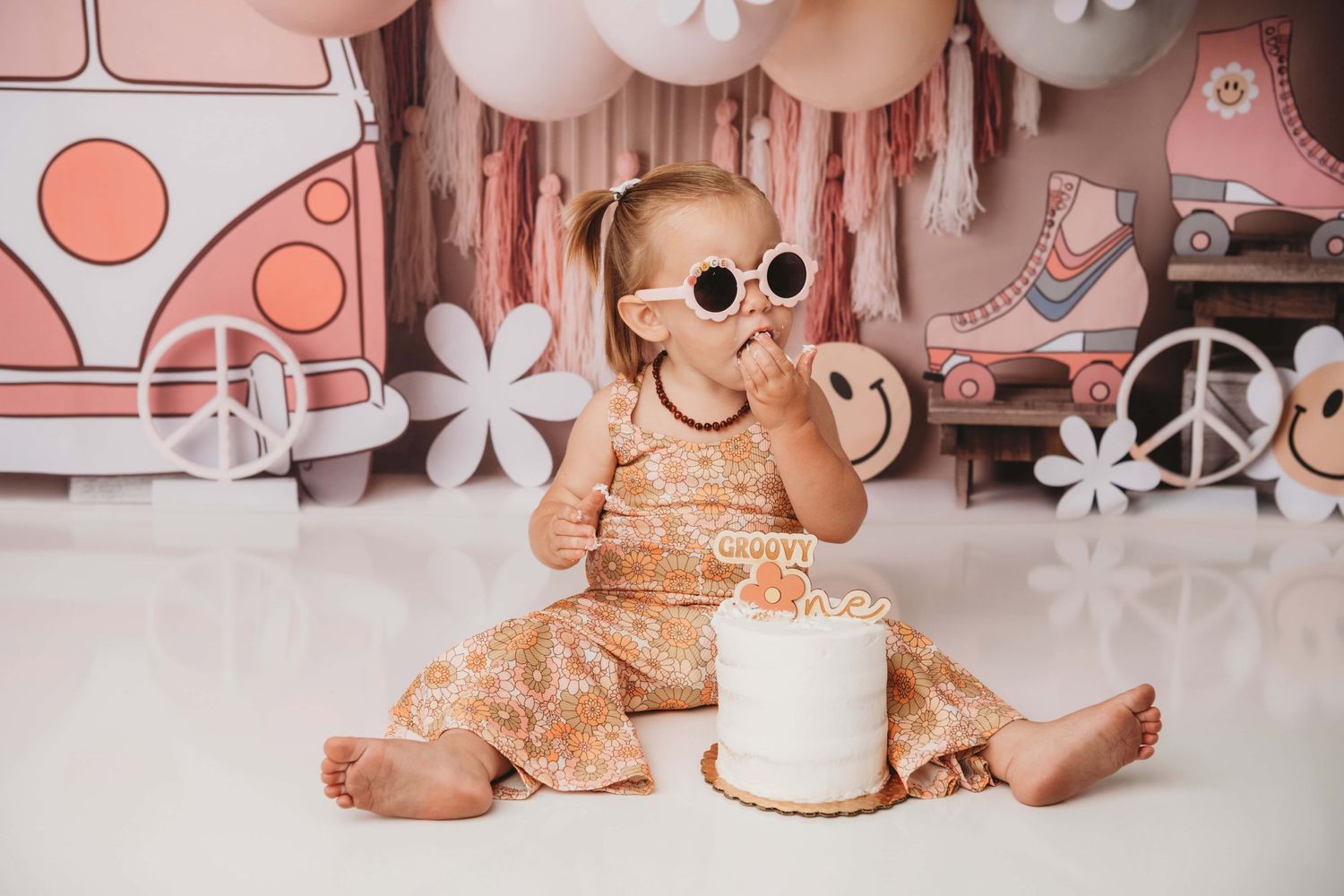 A portrait of a one year old wearing sunglasses for a groovy one themed cake smash photoshoot.