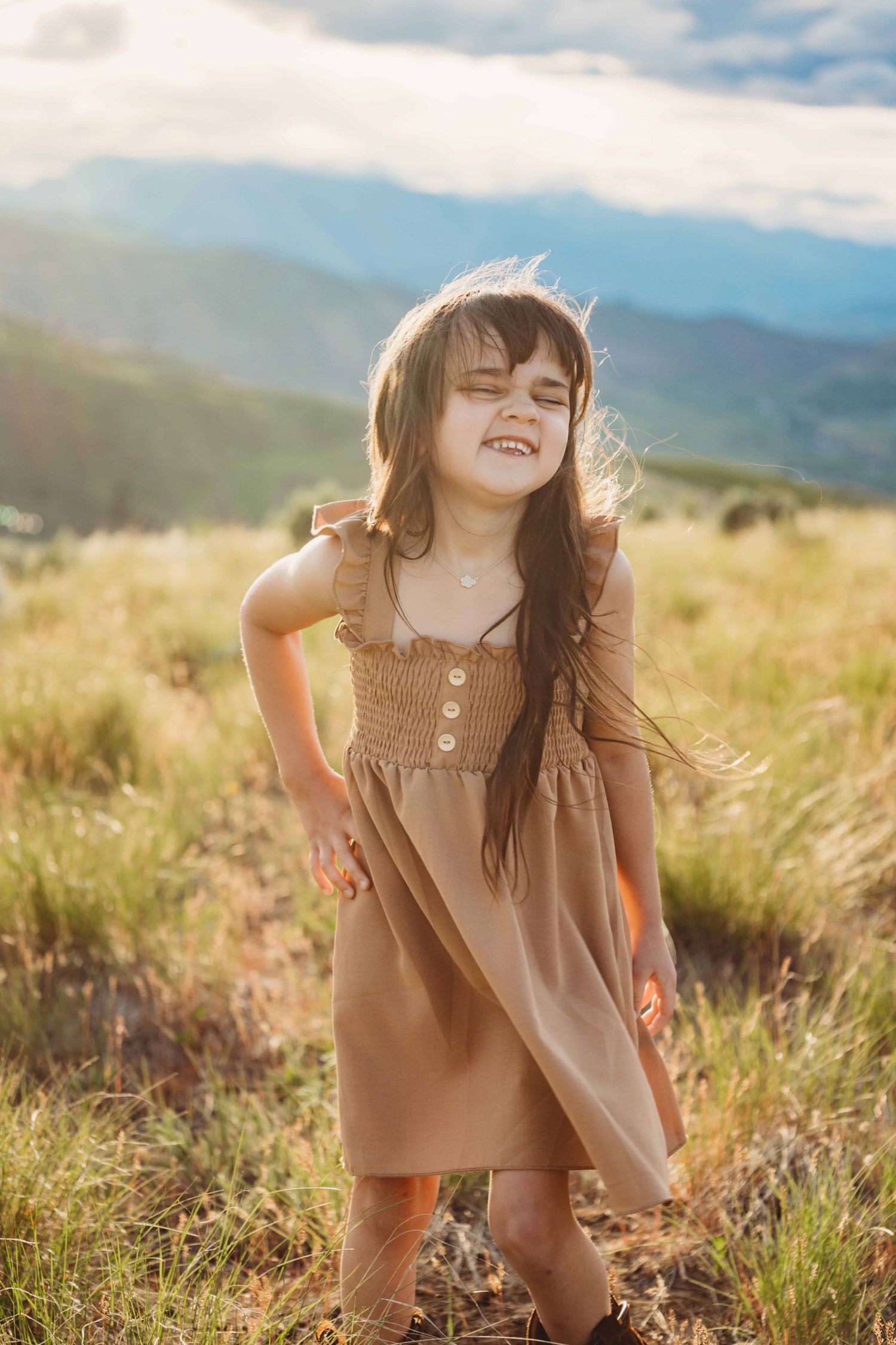 A child wearing a brown dress with soft sunlight in spring time.