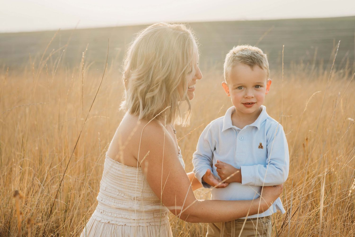 Mother and child portrait by a Wenatchee photographer capturing a tender moment in a sunlit field.
