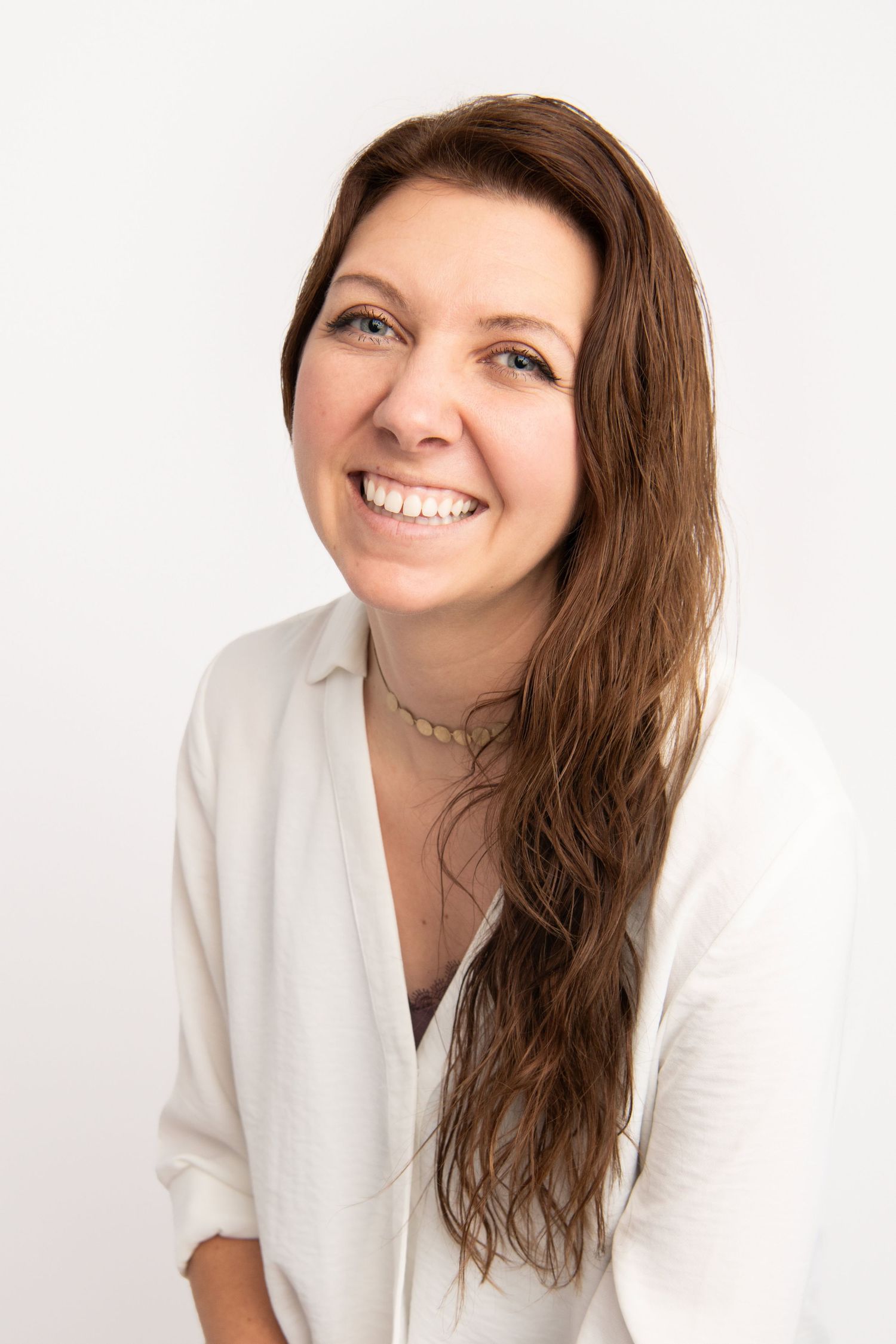 A Walla Walla photographer captures a woman smiling on a white backdrop.