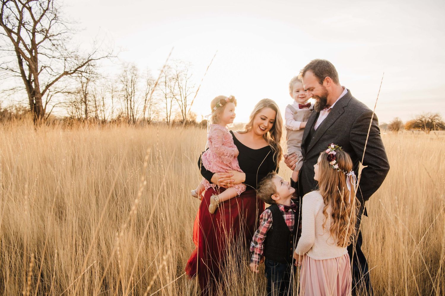 Walla Walla family photographer capturing parents and children sharing a joyful moment together in an open field.