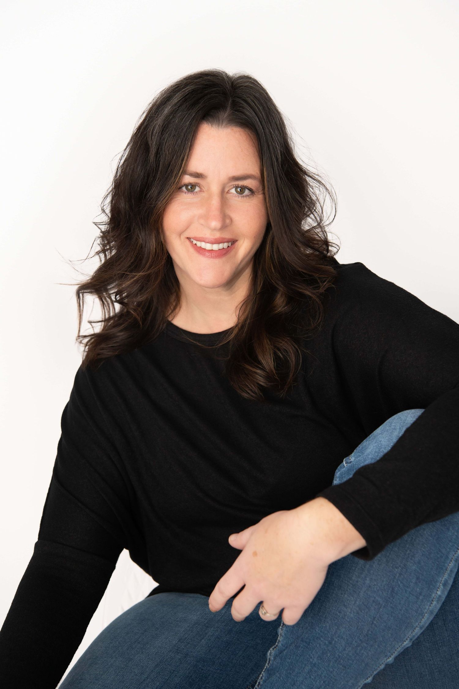 Minimal studio headshot with natural posing and soft, even lighting