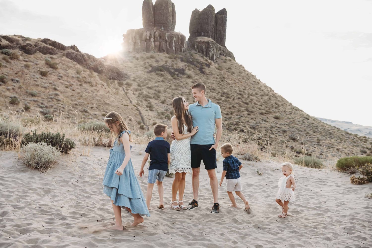 A candid photo of a family with four children with a mountain in the background.