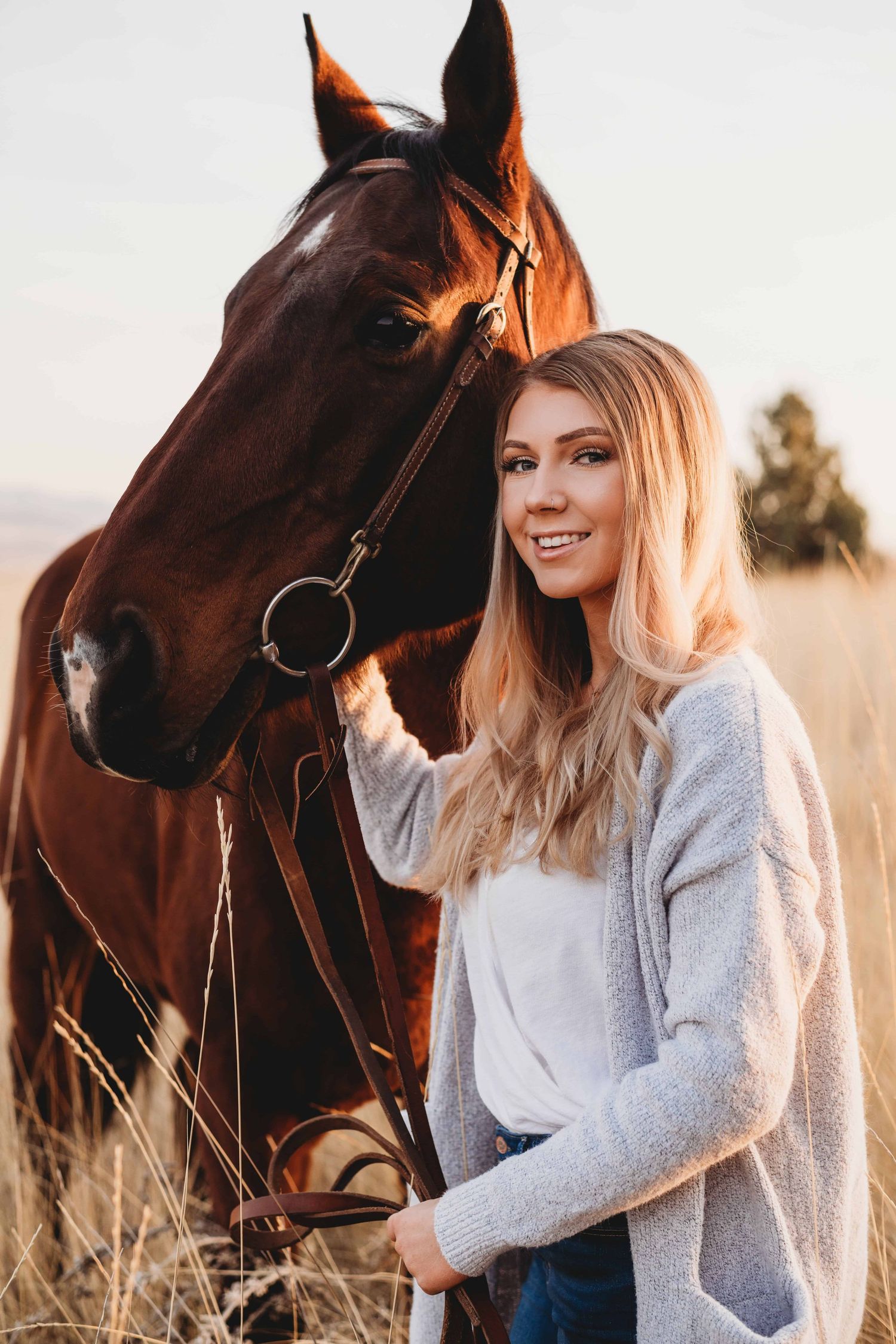 A portrait of a girl posing with her horse as she smiles for the camera, taken by a Walla Walla senior photographer.
