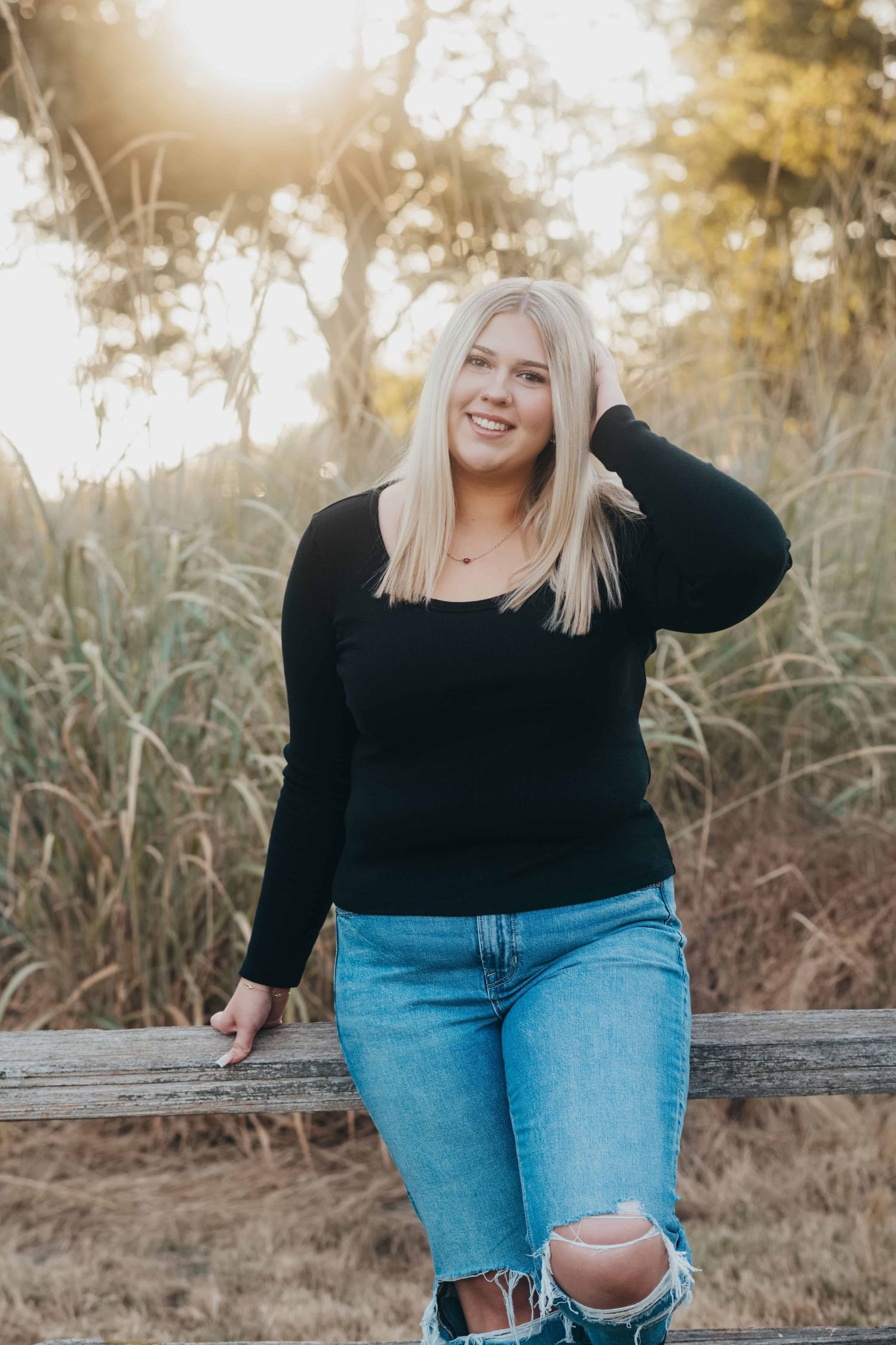 A high school senior portrait of a girl standing in front of an old fence at Whitman Mission in Walla Walla, Washington.