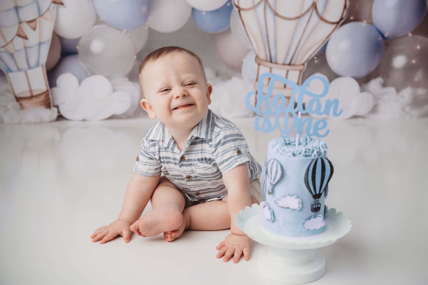 A portrait taken by a Walla Walla photographer of a one year old boy on a hot air balloon backdrop.