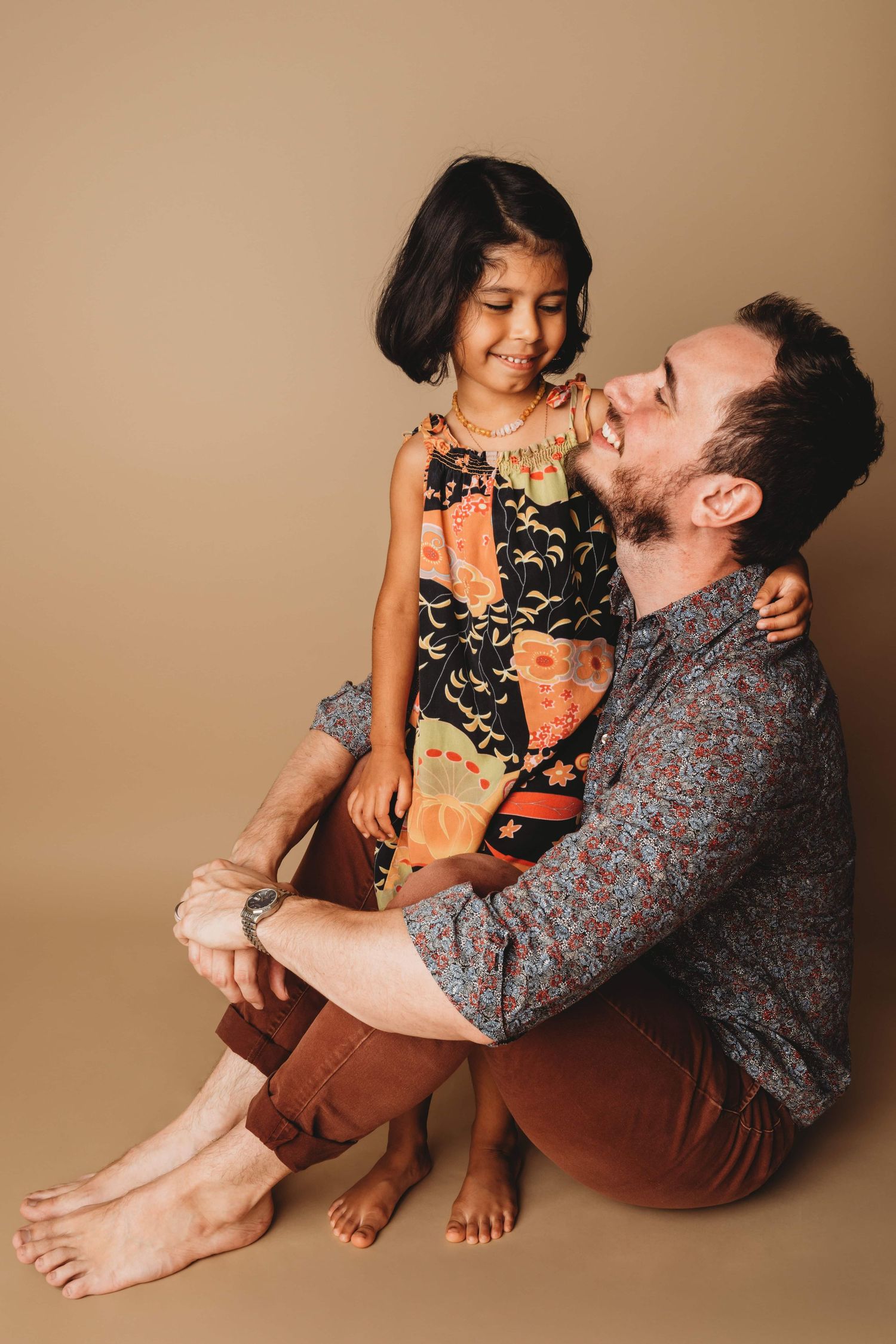 A portrait of a dad and daughter looking at each other for an authentic candid moment.