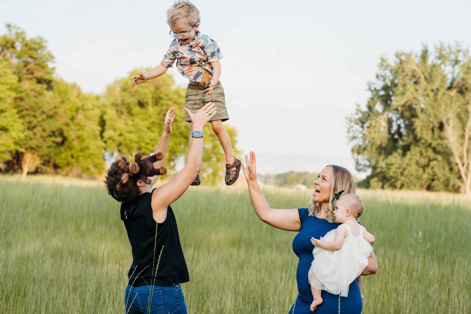 A family of four playing together in a green field at Whitman Mission in Walla Walla.