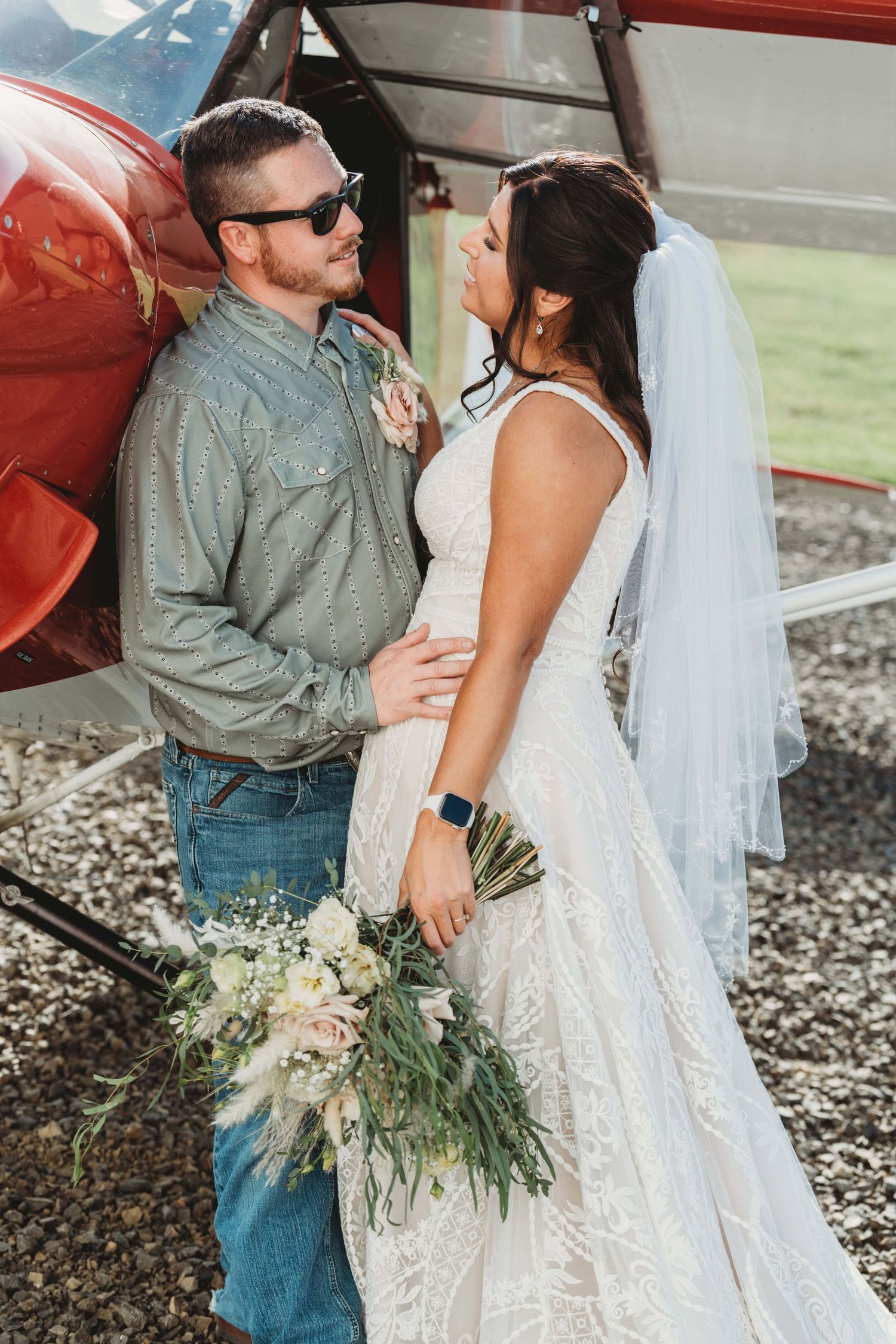 A bride and groom leaning against a private jet after their wedding ceremony in Richland