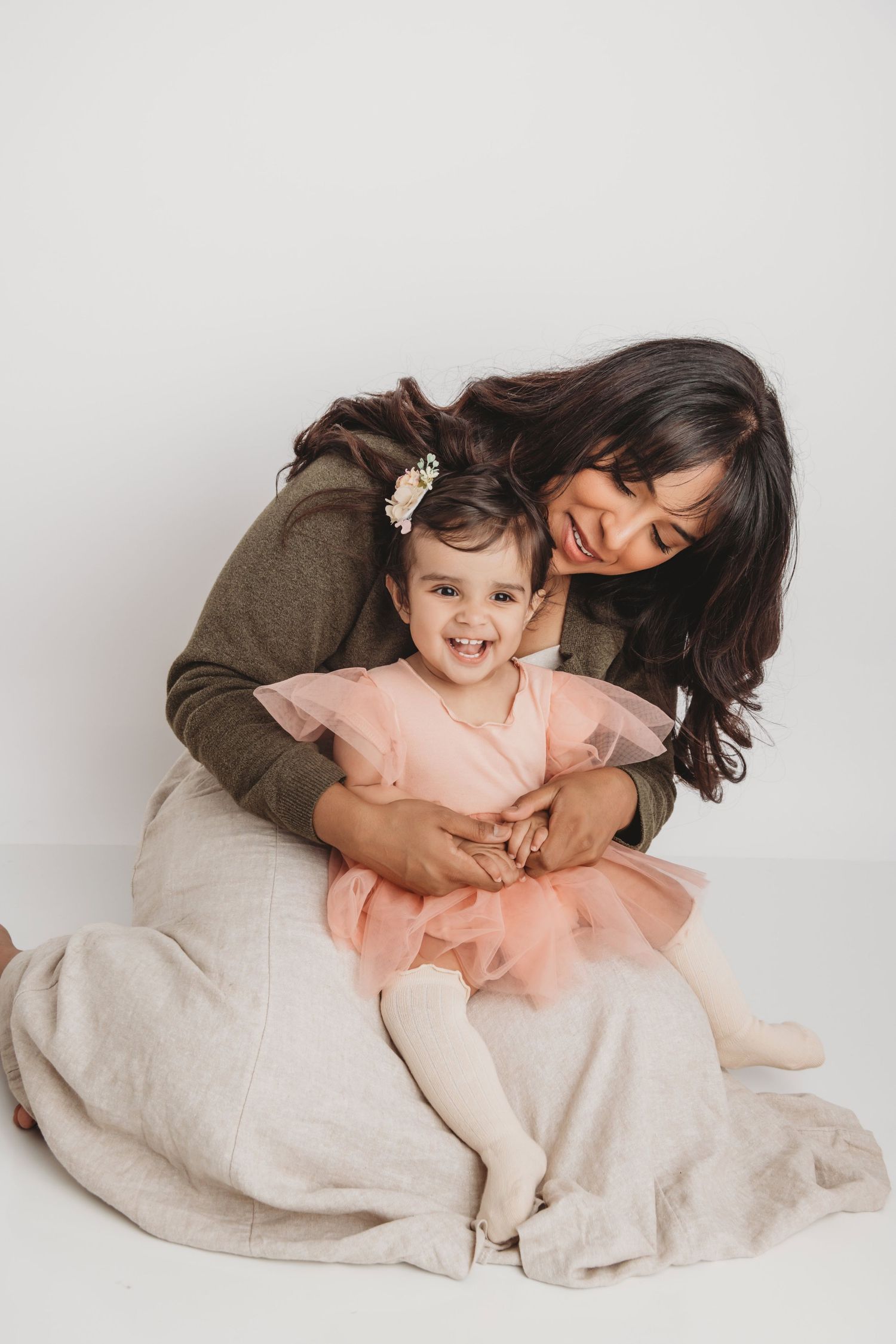 A portrait of a mom and her daughter on a white backdrop in a Walla Walla studio.