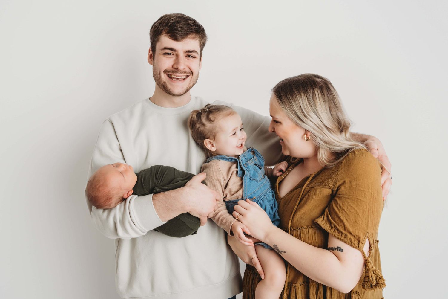 An authentic candid portrait of a family with their newborn baby and toddler at a Walla Walla photography studio.