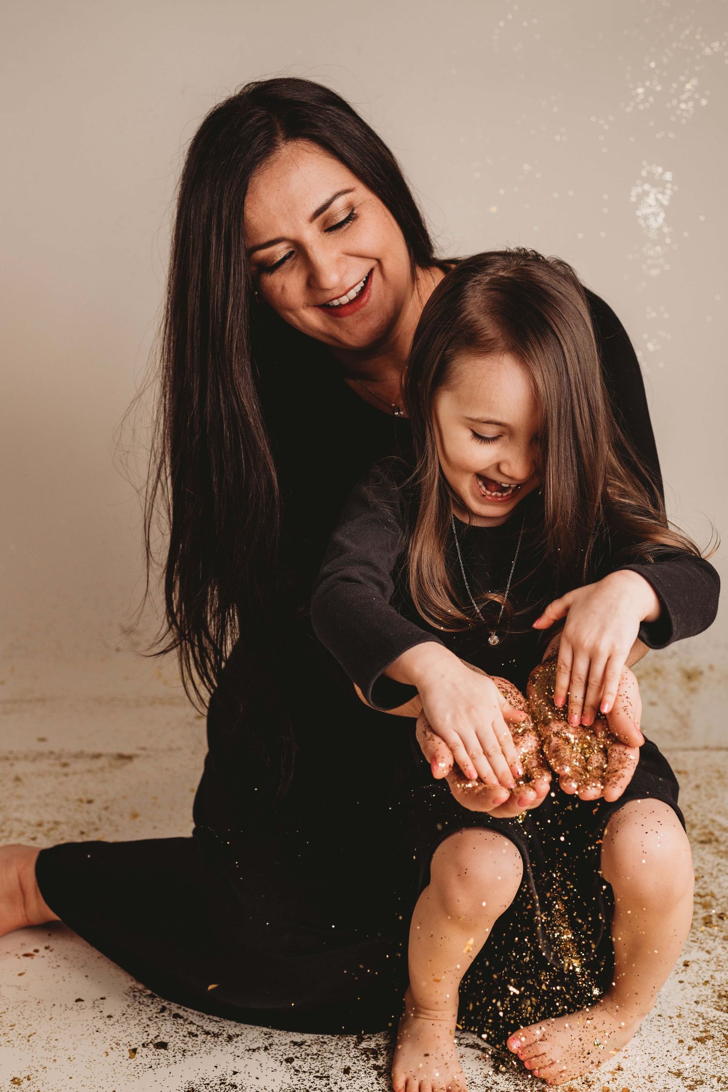 Mother and child portrait by a Walla Walla photographer, capturing a joyful moment with hands covered in glitter.