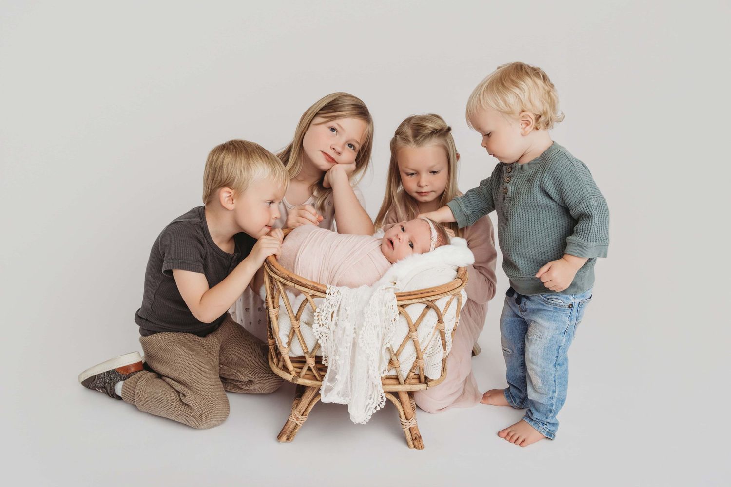A portrait of a newborn baby girl in a bassinet surrounded by her four siblings, created for a Richland, Washington family.
