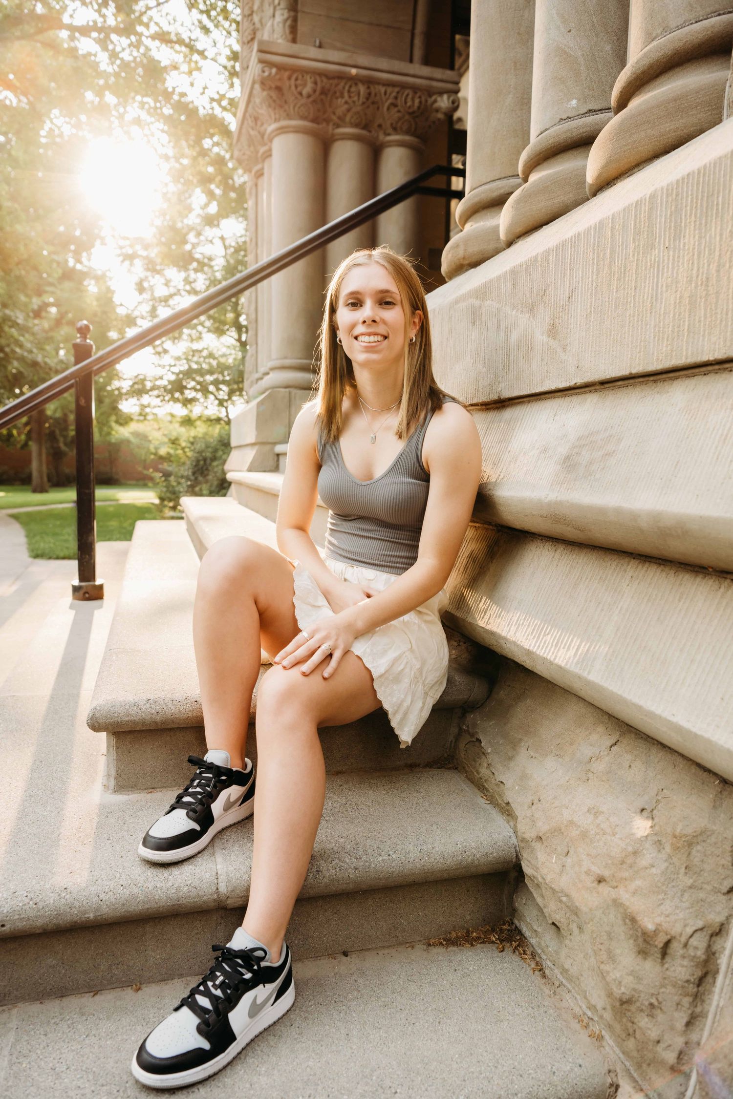 A young woman sitting on the steps at Whitman College in Walla Walla.