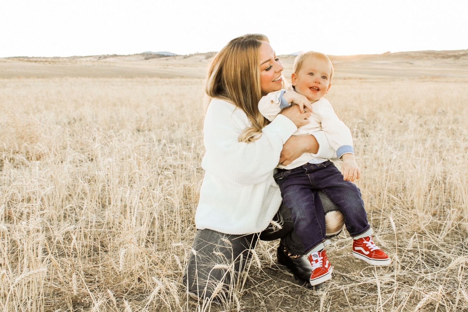 Family bonding moments photographed in rustic field setting at golden hour.