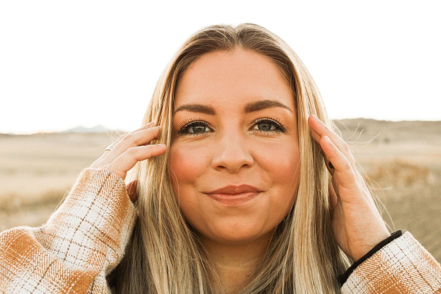 Close-up portrait outdoors with natural lighting and desert background.