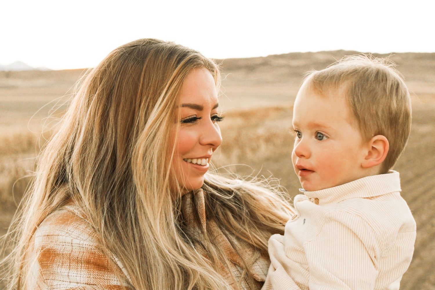 Candid family moments captured in warm sunlit field.