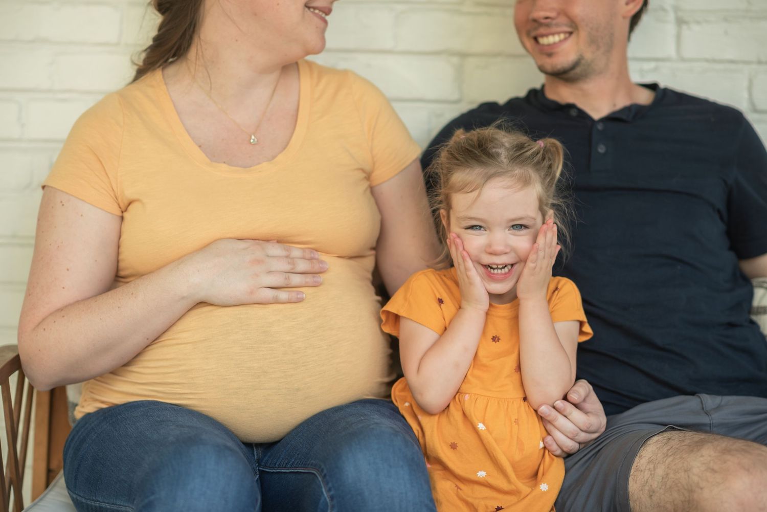 Pregnant woman seated with her partner and toddler during a family maternity session in Northern Virginia