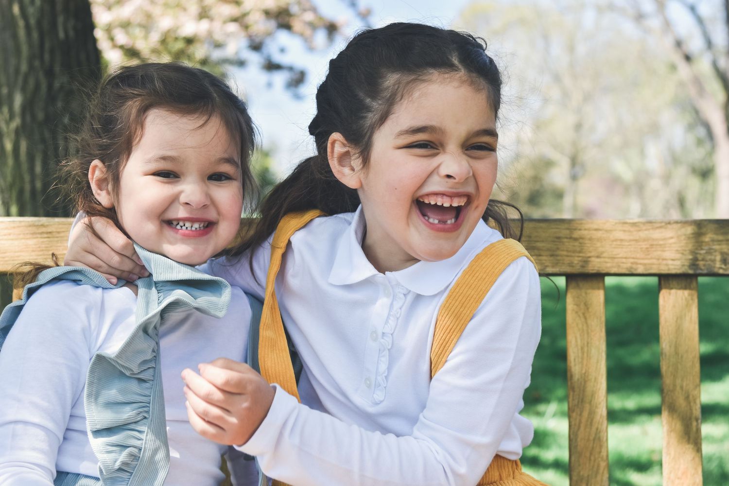 Young siblings laughing outdoors during a natural light family photography session