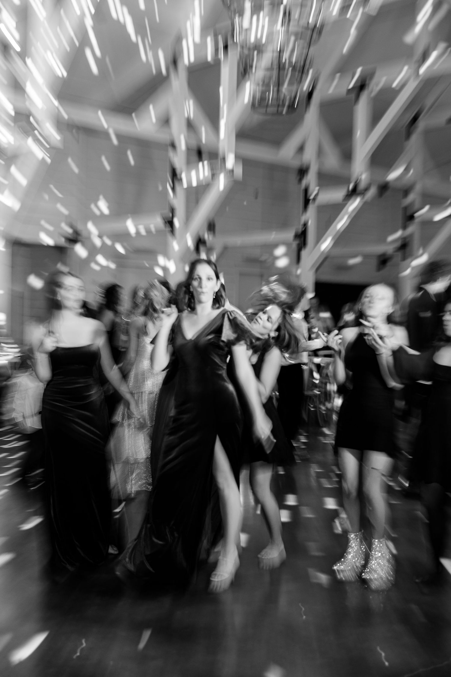 A black-and-white shutter-drag image of a bridesmaid dancing by Memphis wedding photographer Emily Joy Photography.