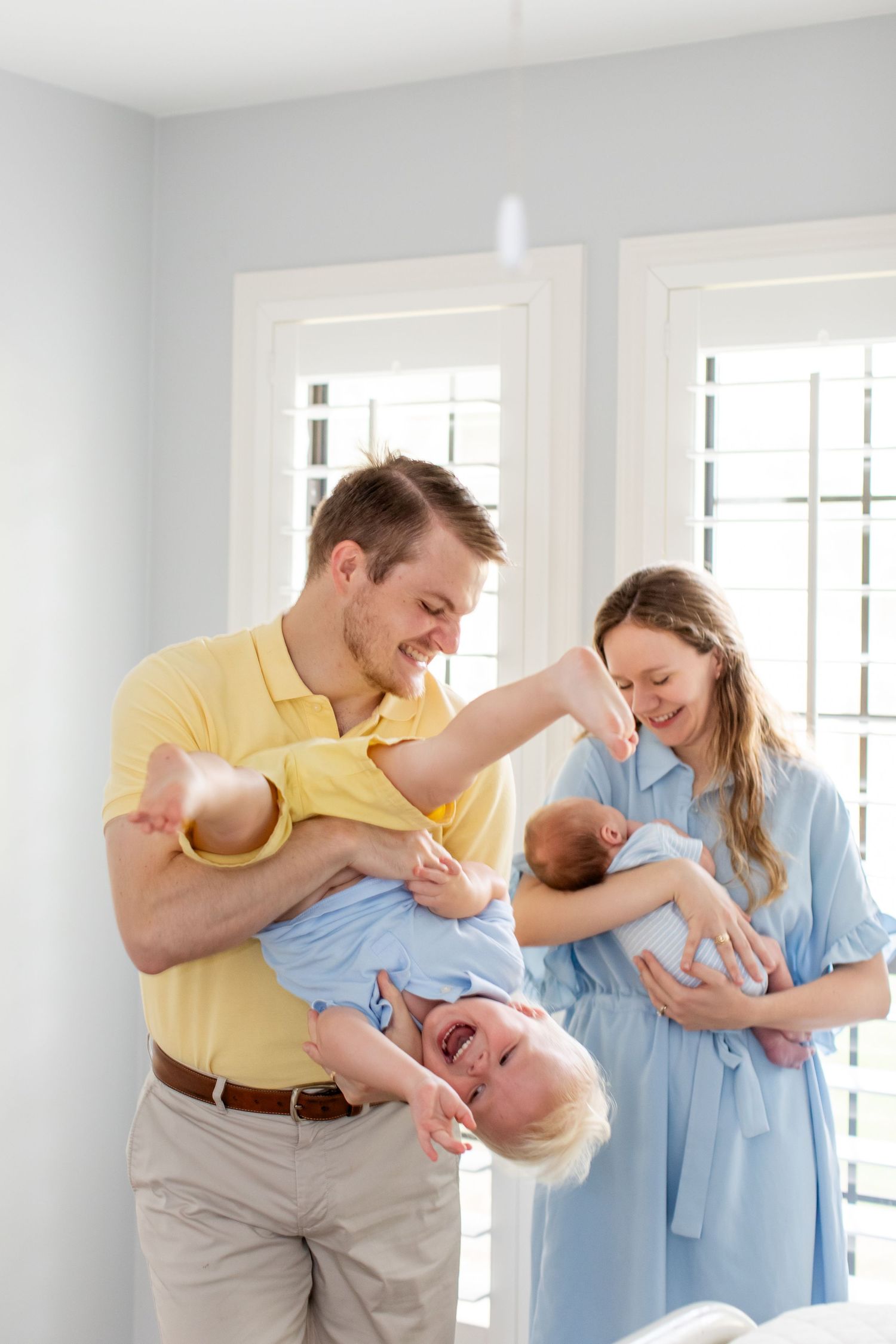 Husband and wife each holding and admiring their two sons for a portrait by Emily Joy Photography, now a wedding photographer in Memphis, TN